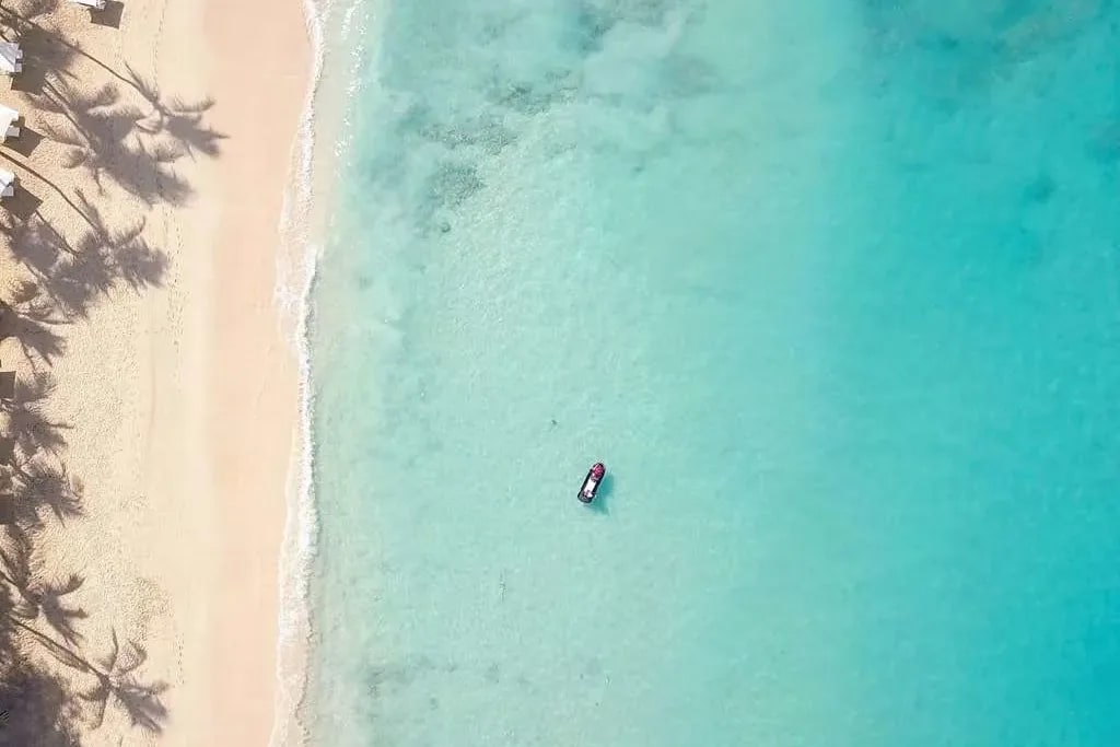 aerial view of a moor boat on a turquoise lagoon