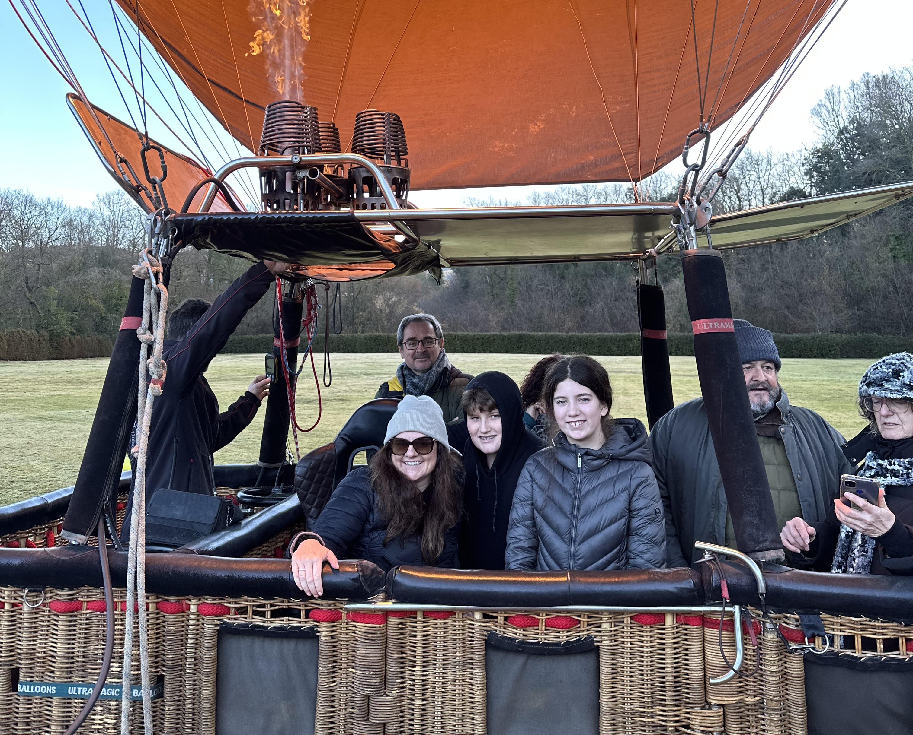 a group of people gets ready to float up in a hot-air balloon