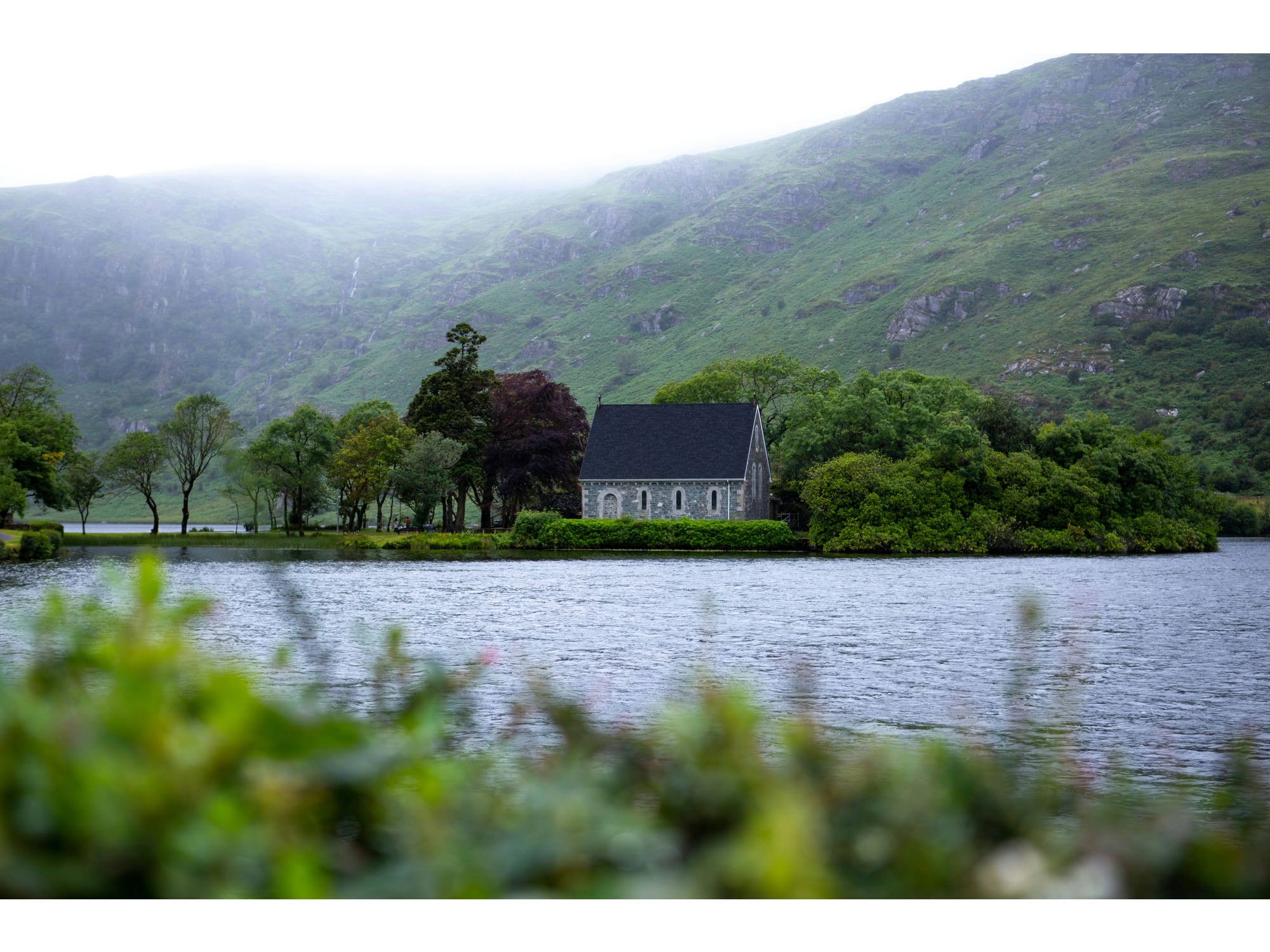 House near mountains and waterbody.