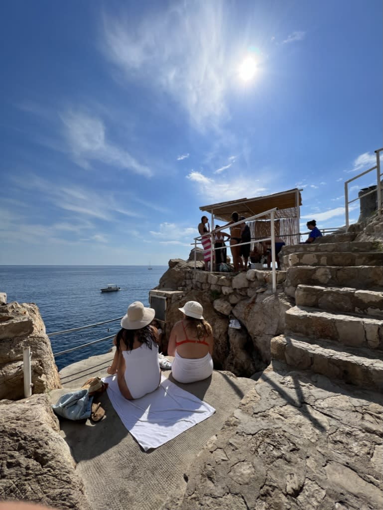 Sitting on the ground and enjoying the views of the sea