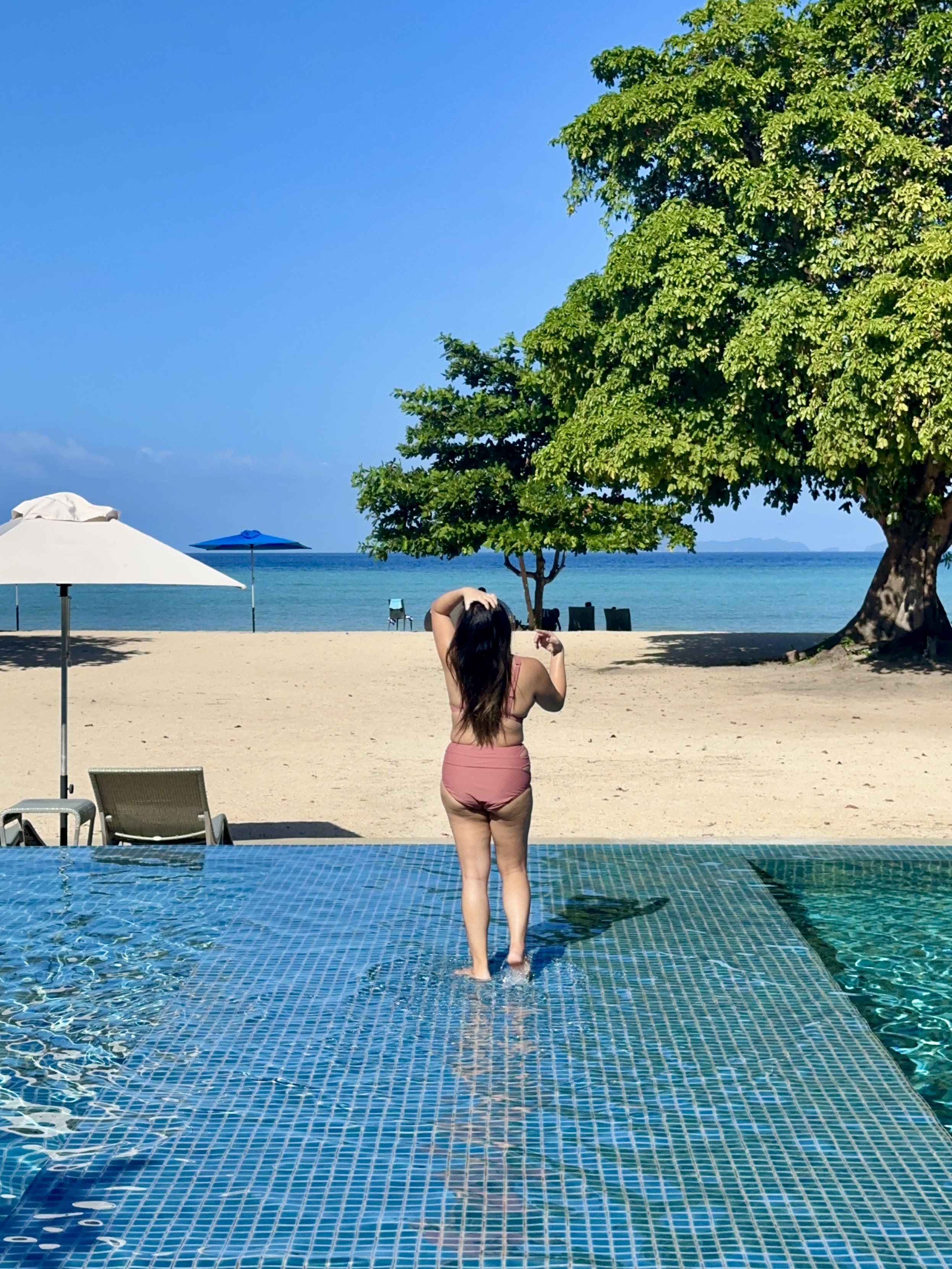 Standing in the pool by the beach