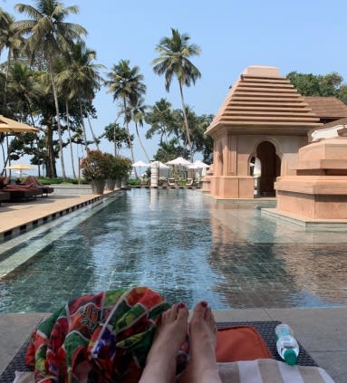 View of pool at Grand Hyatt Goa on a sunny day with palm trees in the distance