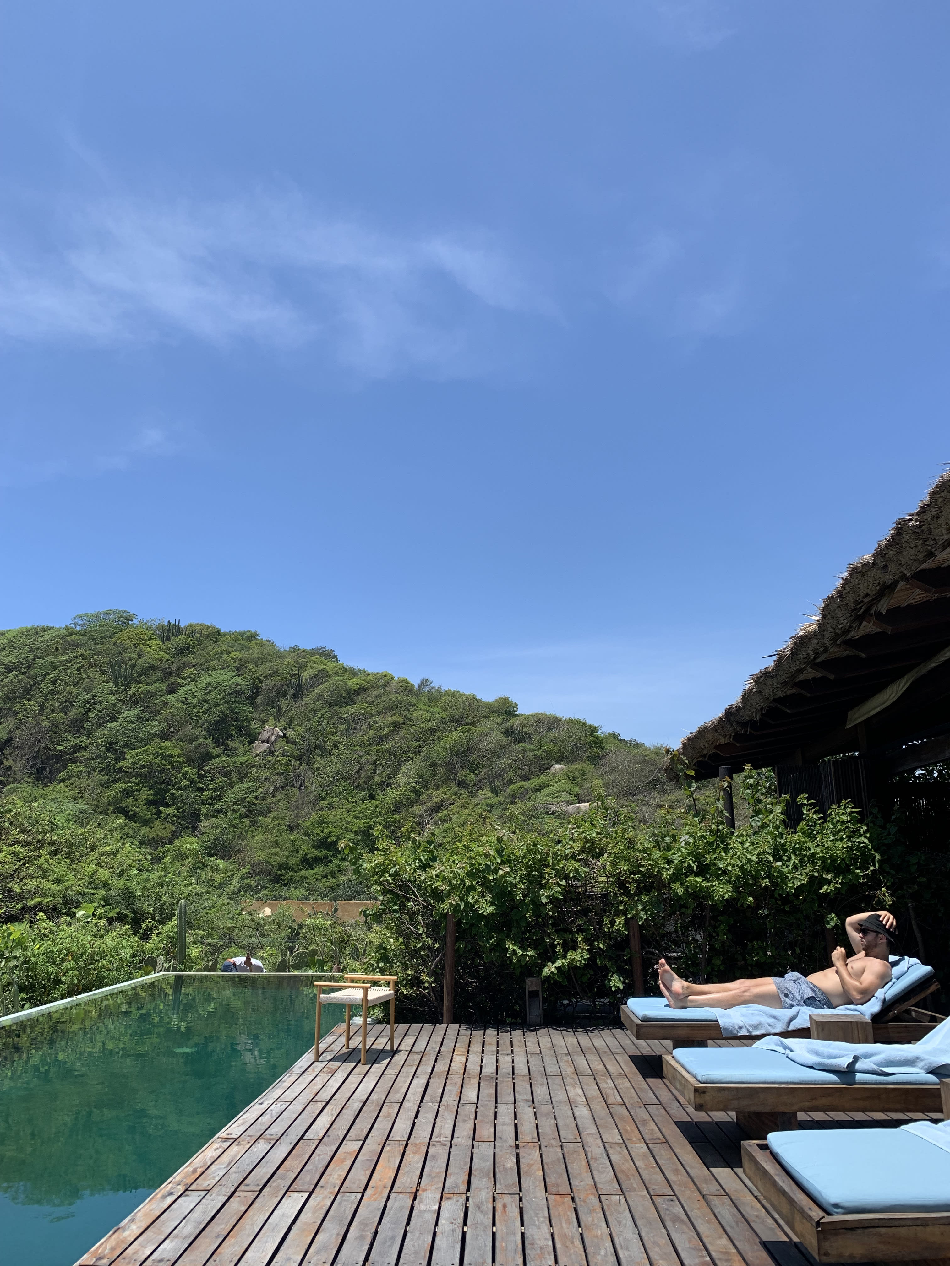 Picture of a man sitting on sunloungers beside the pool