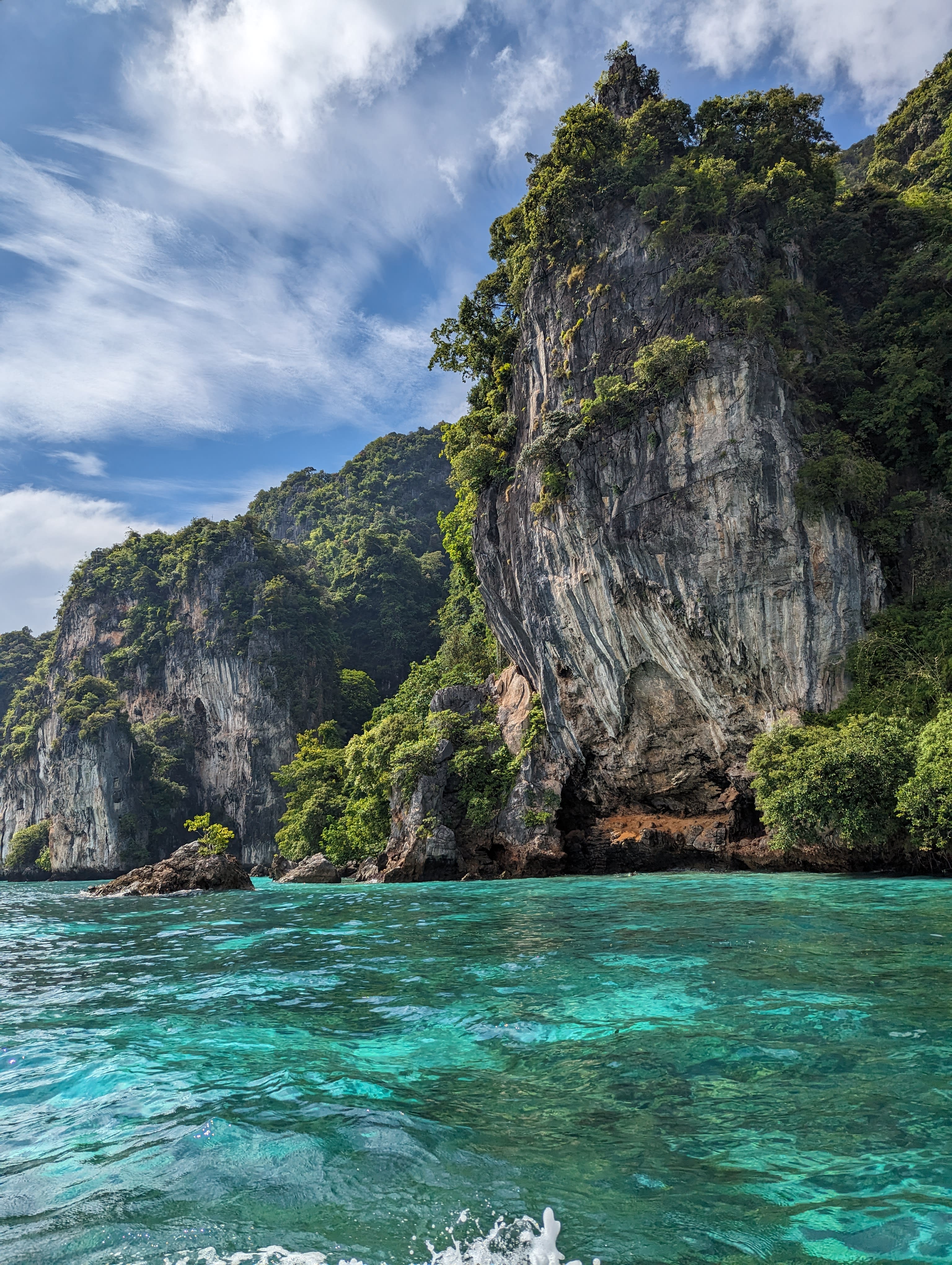 Beautiful view of cliffs lush with vegetation towering above clear turquoise water