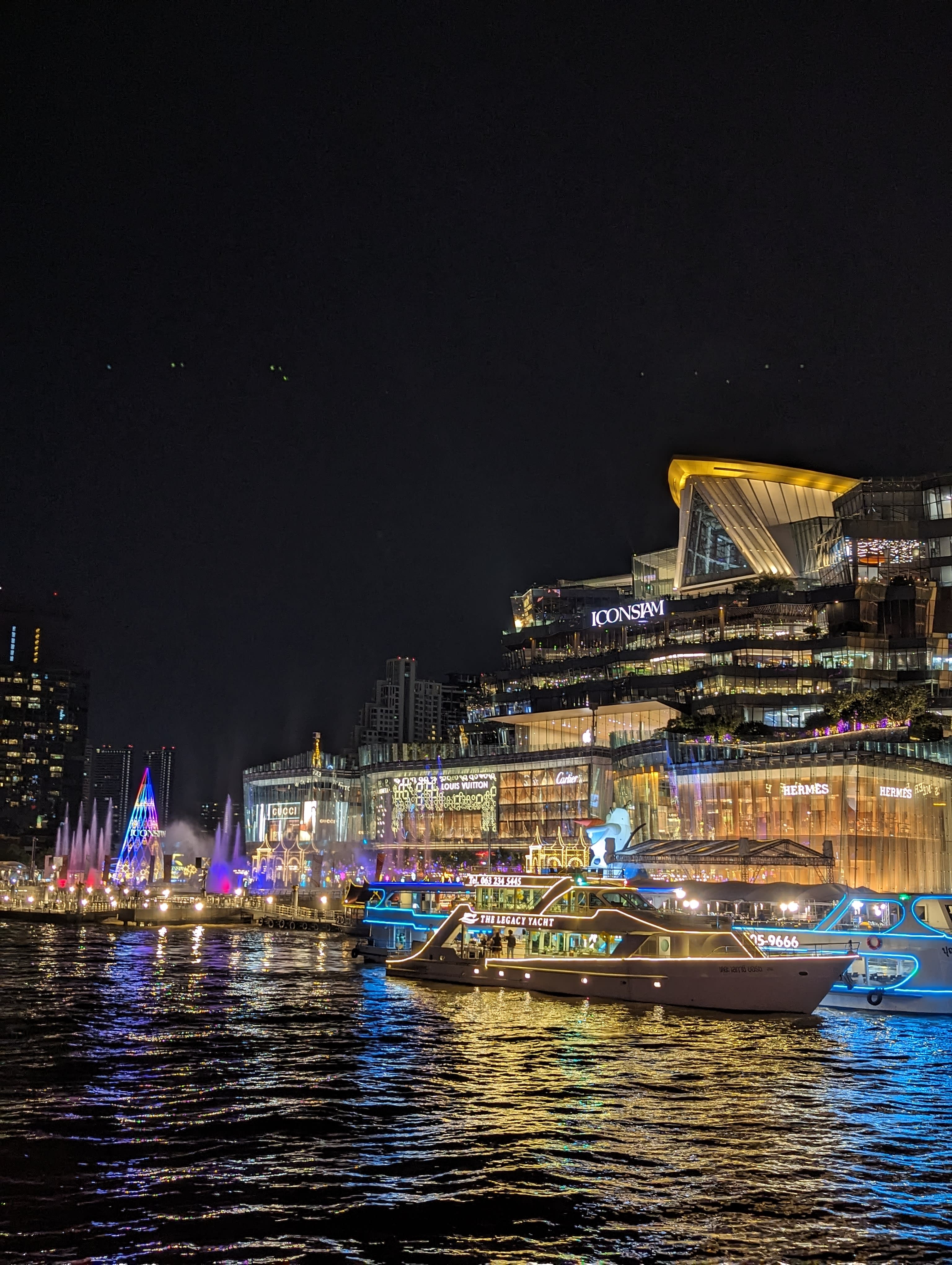 Beautiful view from the water of Iconsiam Bangkok shopping center brightly lit at night