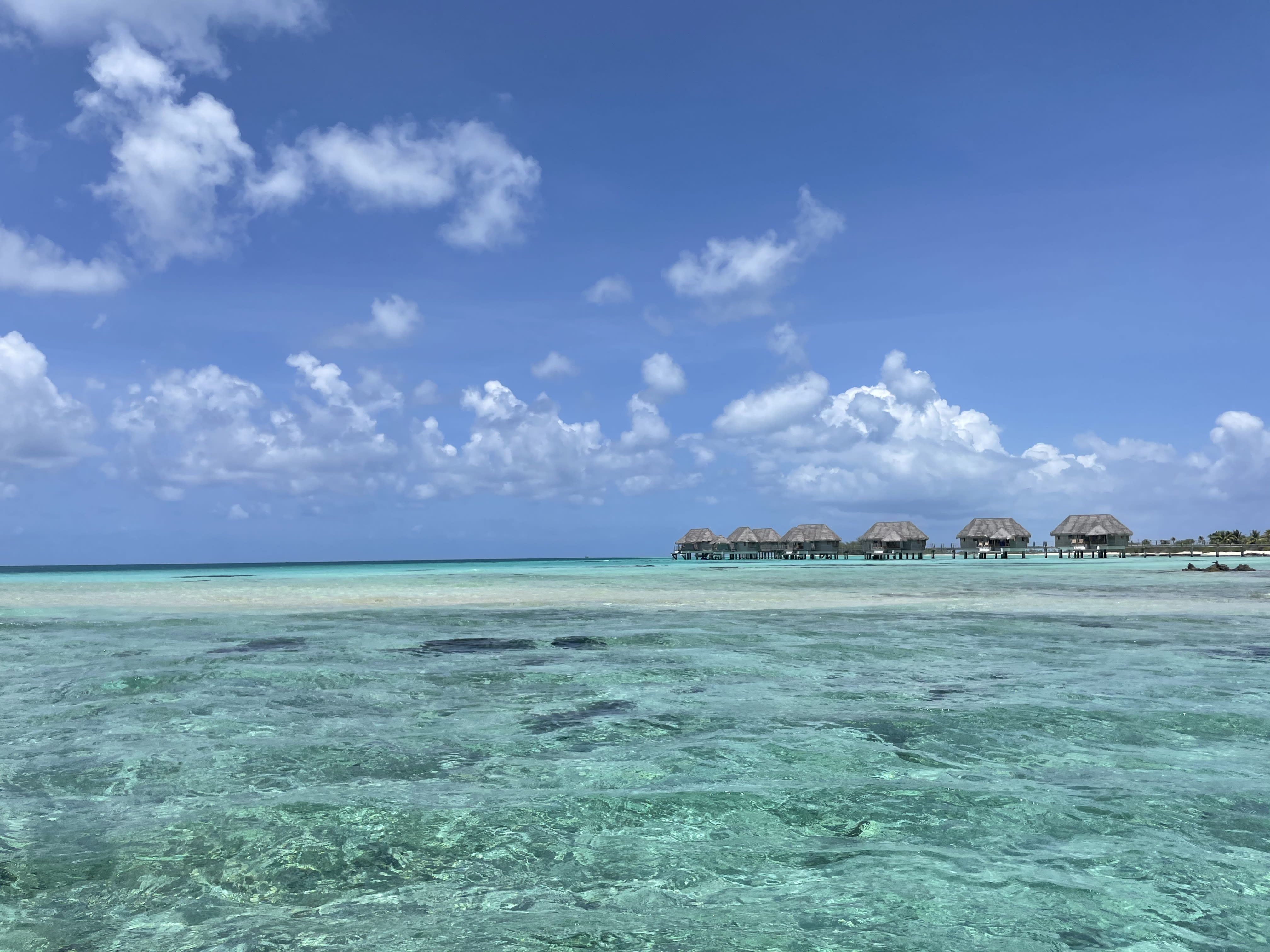 Beautiful clear blue water of the sea and view of water lodges in a distance
