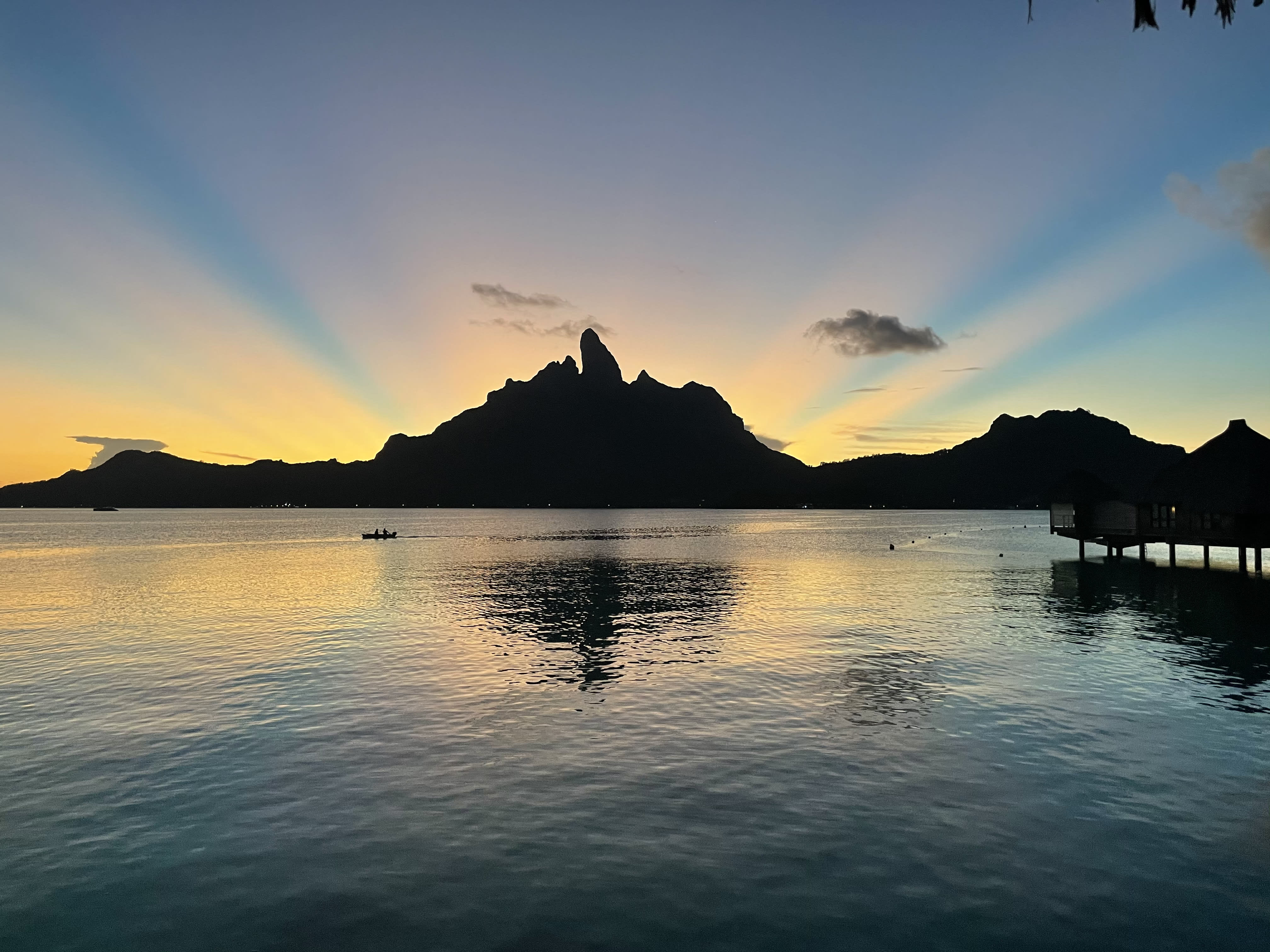 Colors of sunset behind the mountains reflected in the sea