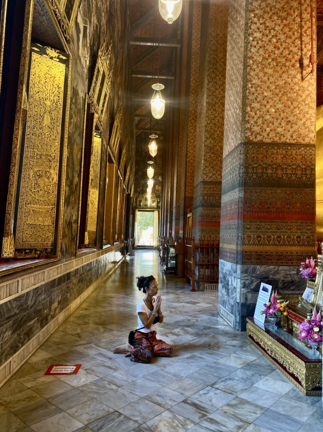 Picture of Sabina sitting on the marble floor in a temple with large columns and high ceilings