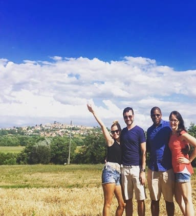 Picture of Kenny posing outside in a field with friends on a sunny day