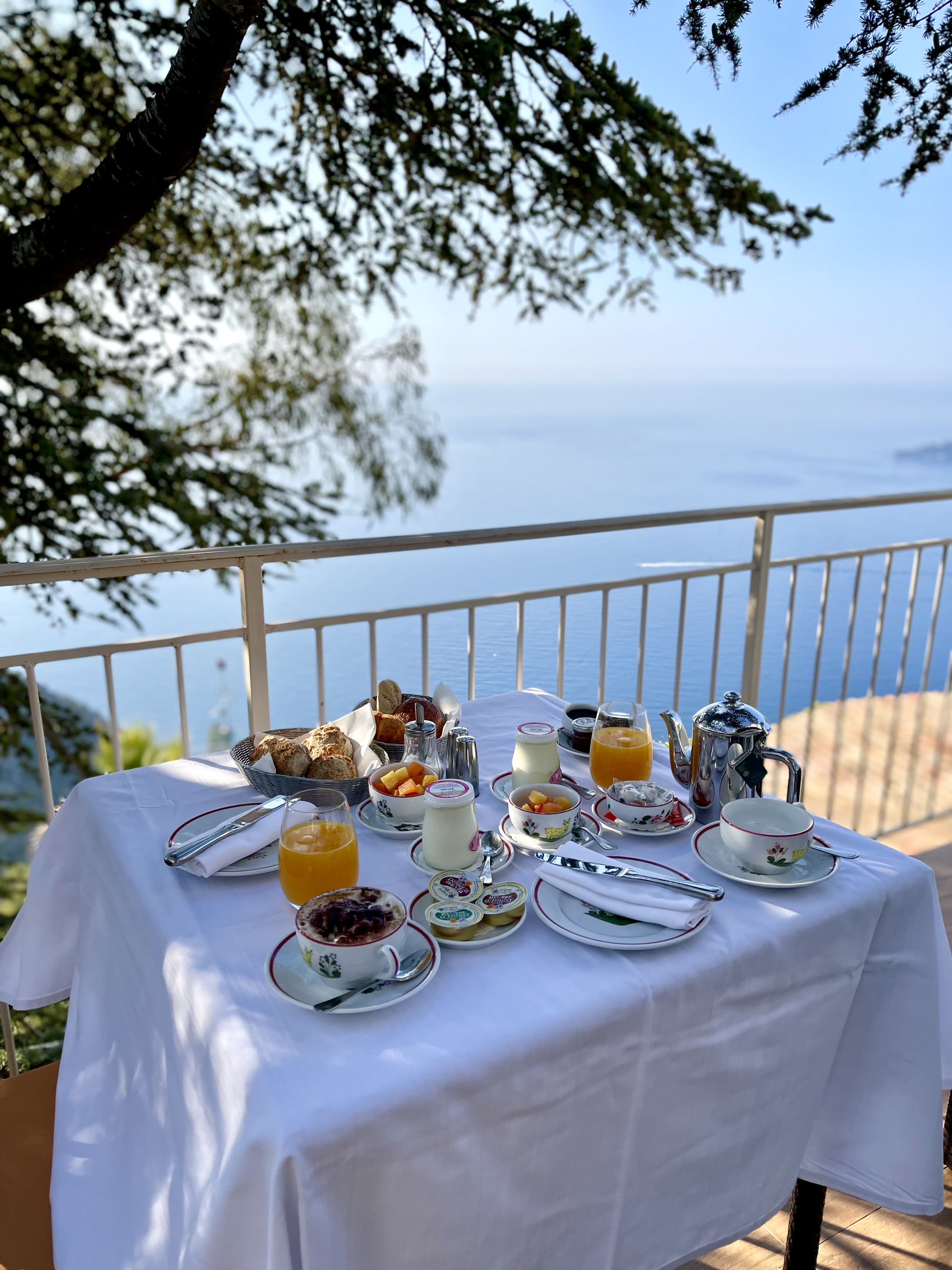 A view of a mean on a balcony during the day with the ocean in the distance.