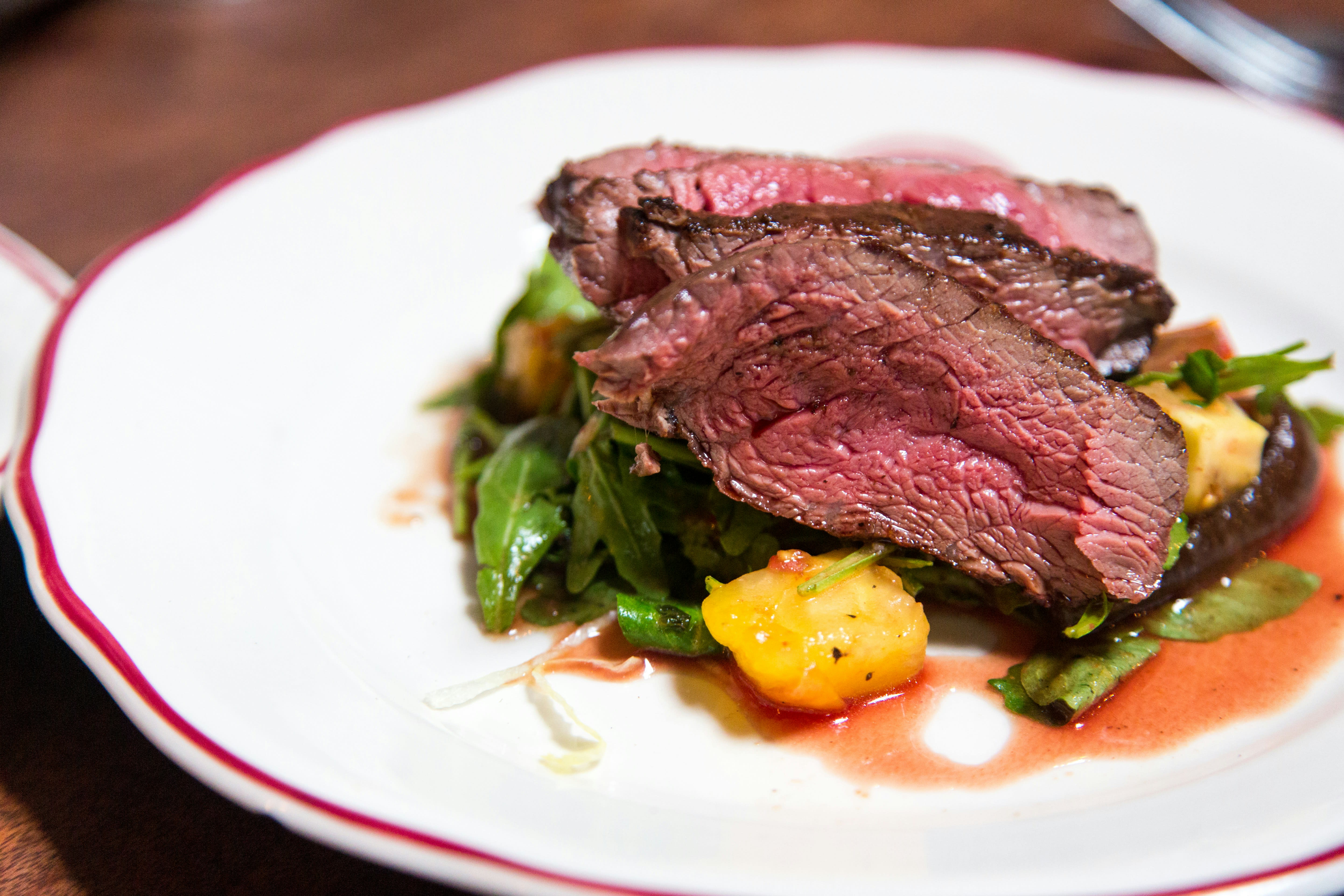 Meat steak on a bed of vegetables.
