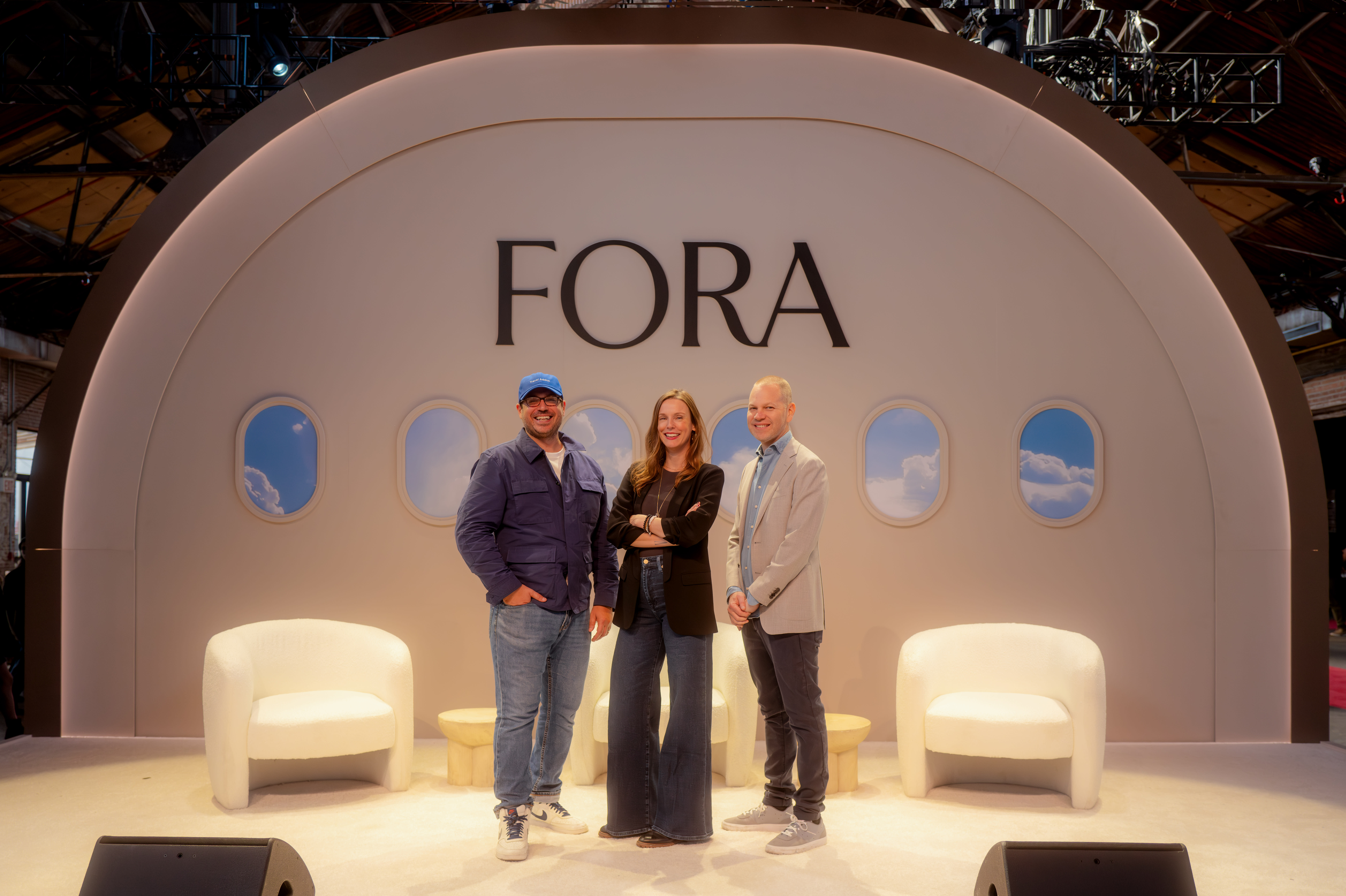 three people standing on a stage designed to look like an airplane