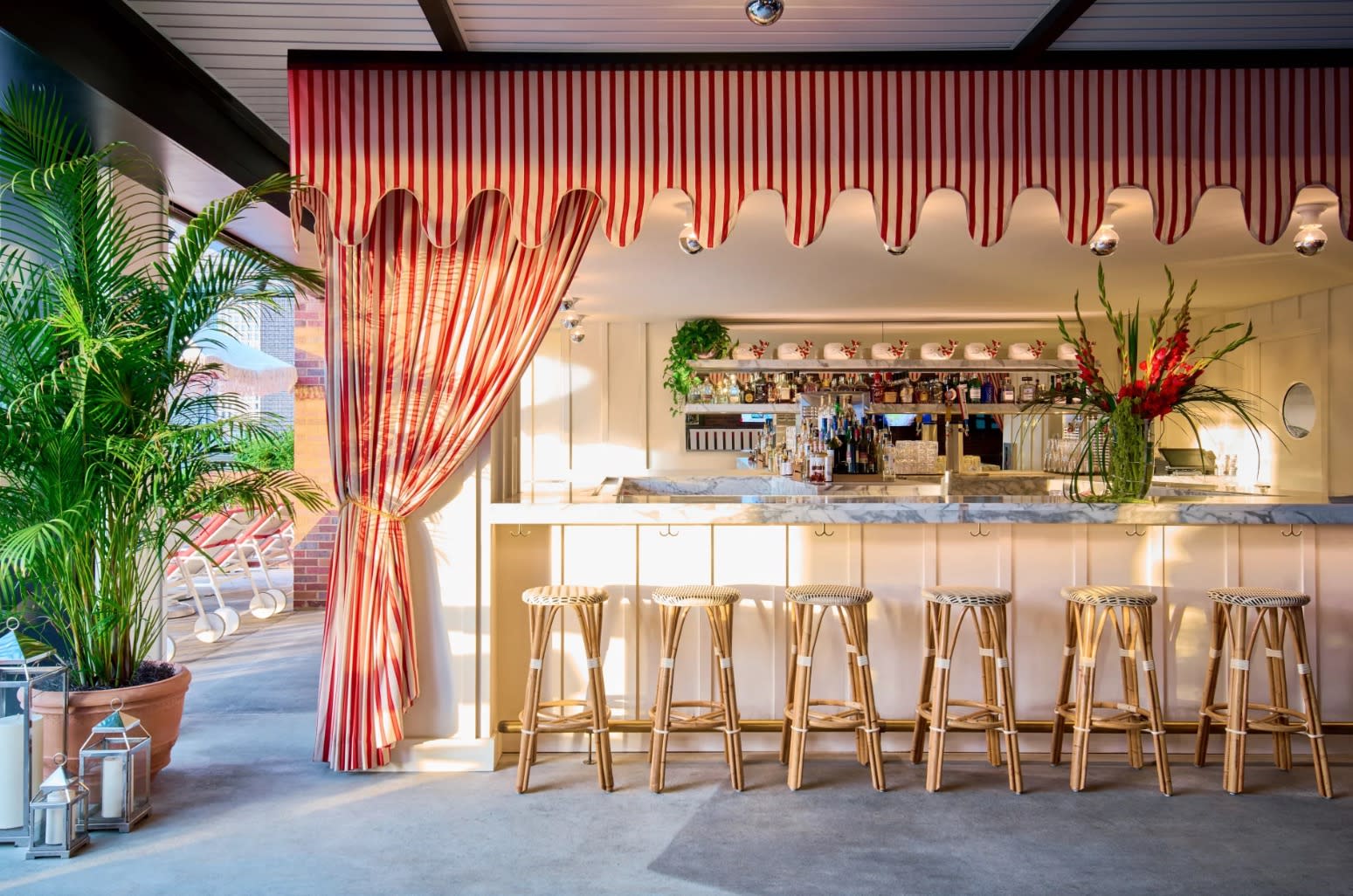 pink and white outdoor bar with stools