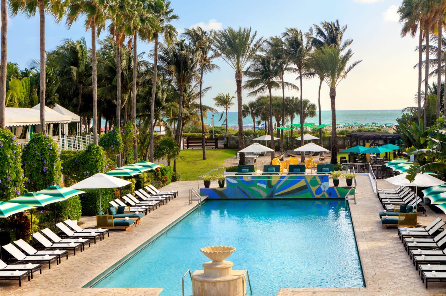 pool with ocean view and surrounding loungers and umbrellas