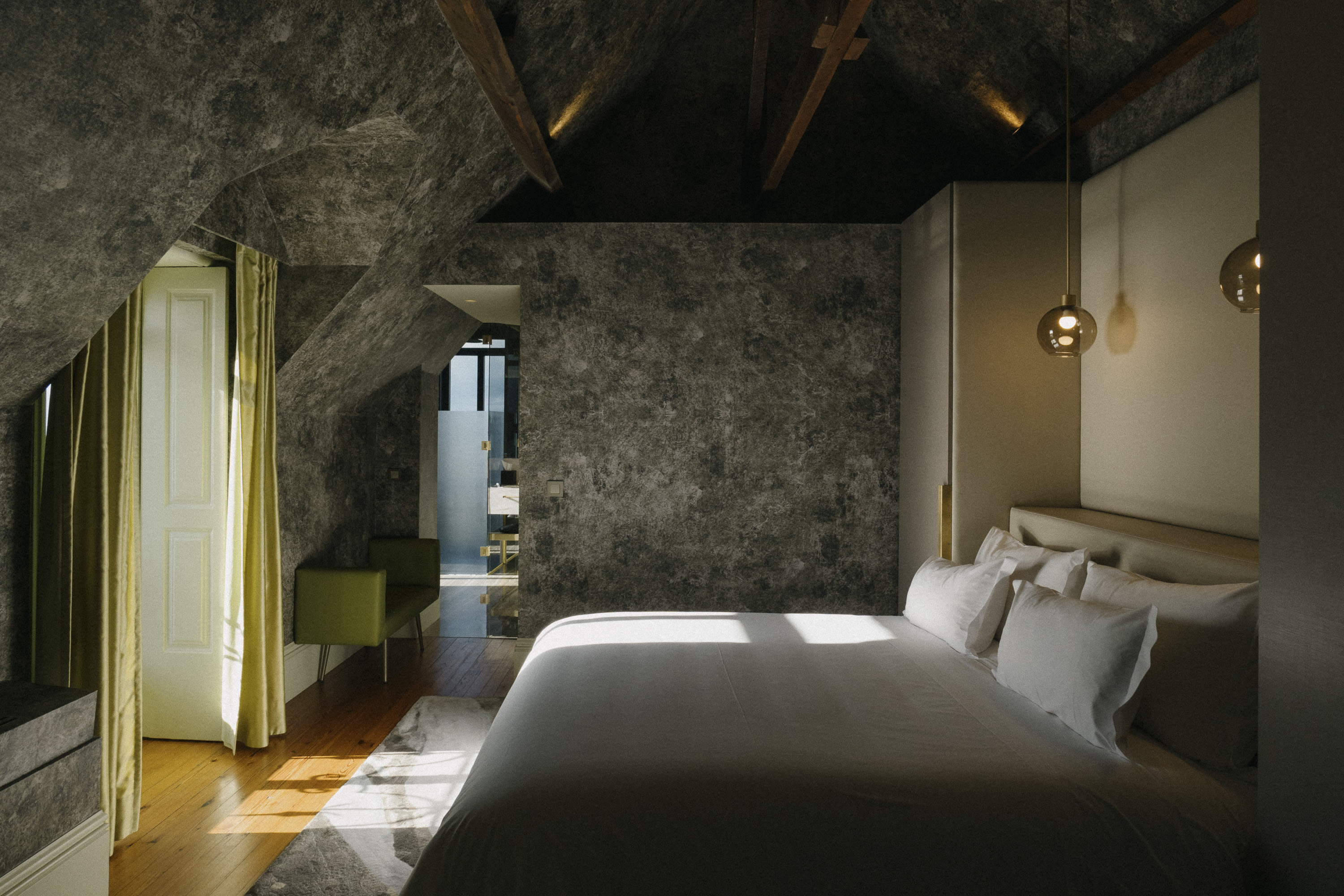 a fancy hotel room with wooden floors and a gray angled ceiling