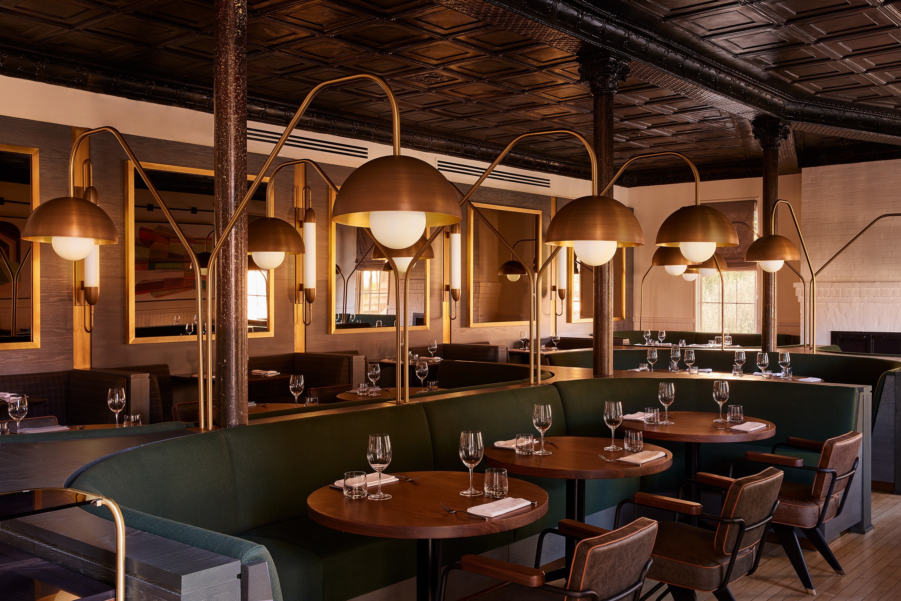 a swanky restaurant dining room with round wooden tables