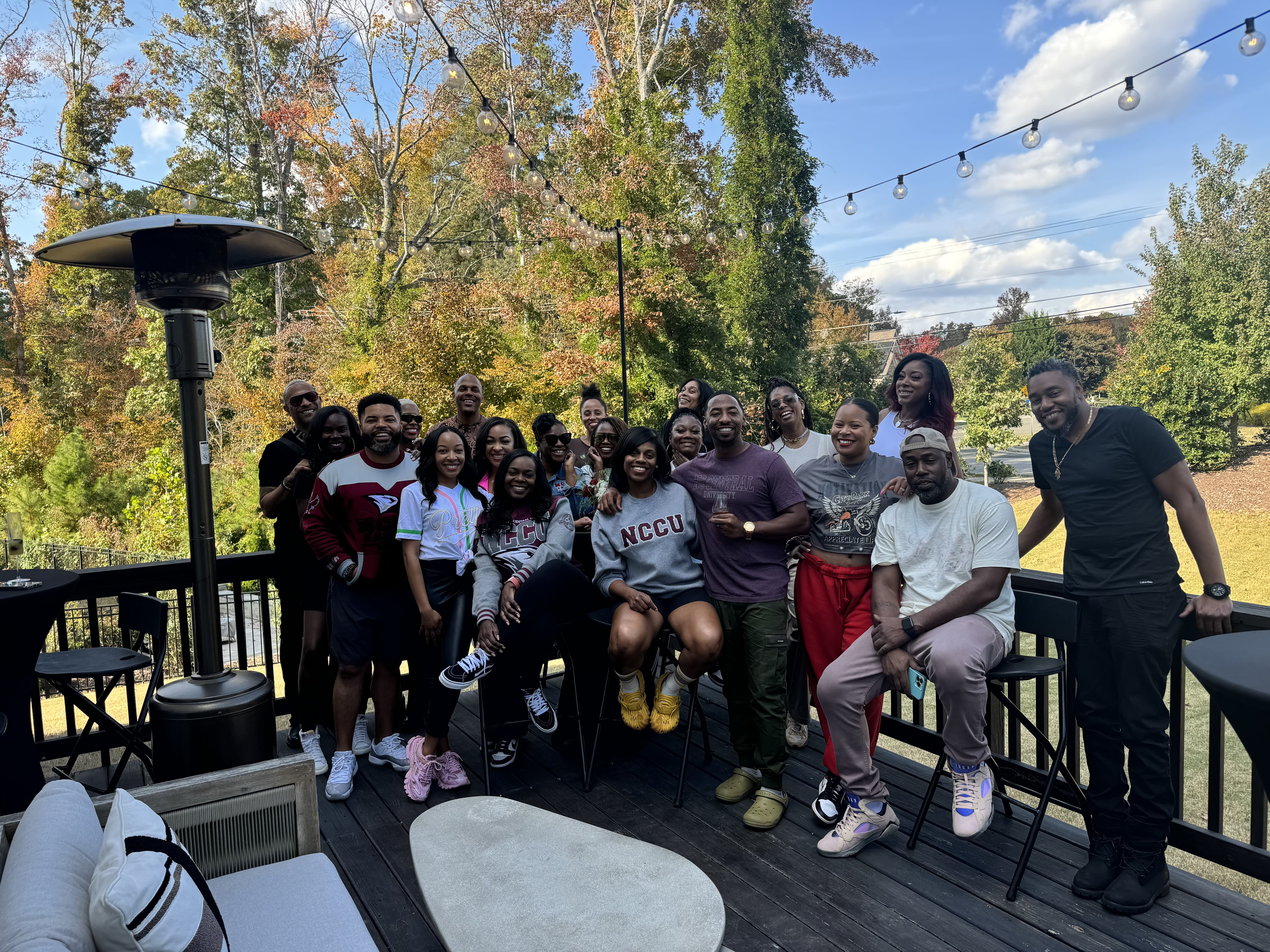 a group of people on a porch near a grassy yard