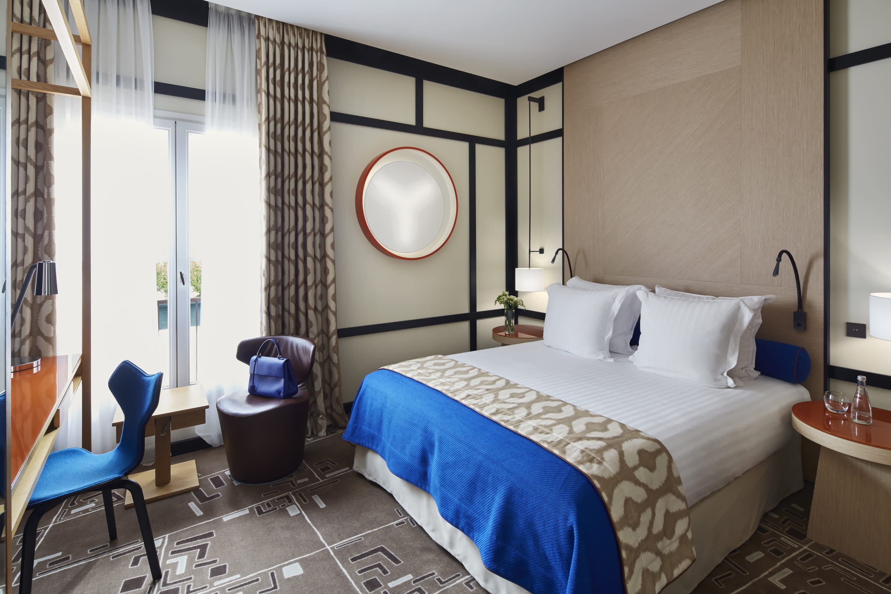 Cozy hotel room with stylish furnishings and bold pops of deep blue