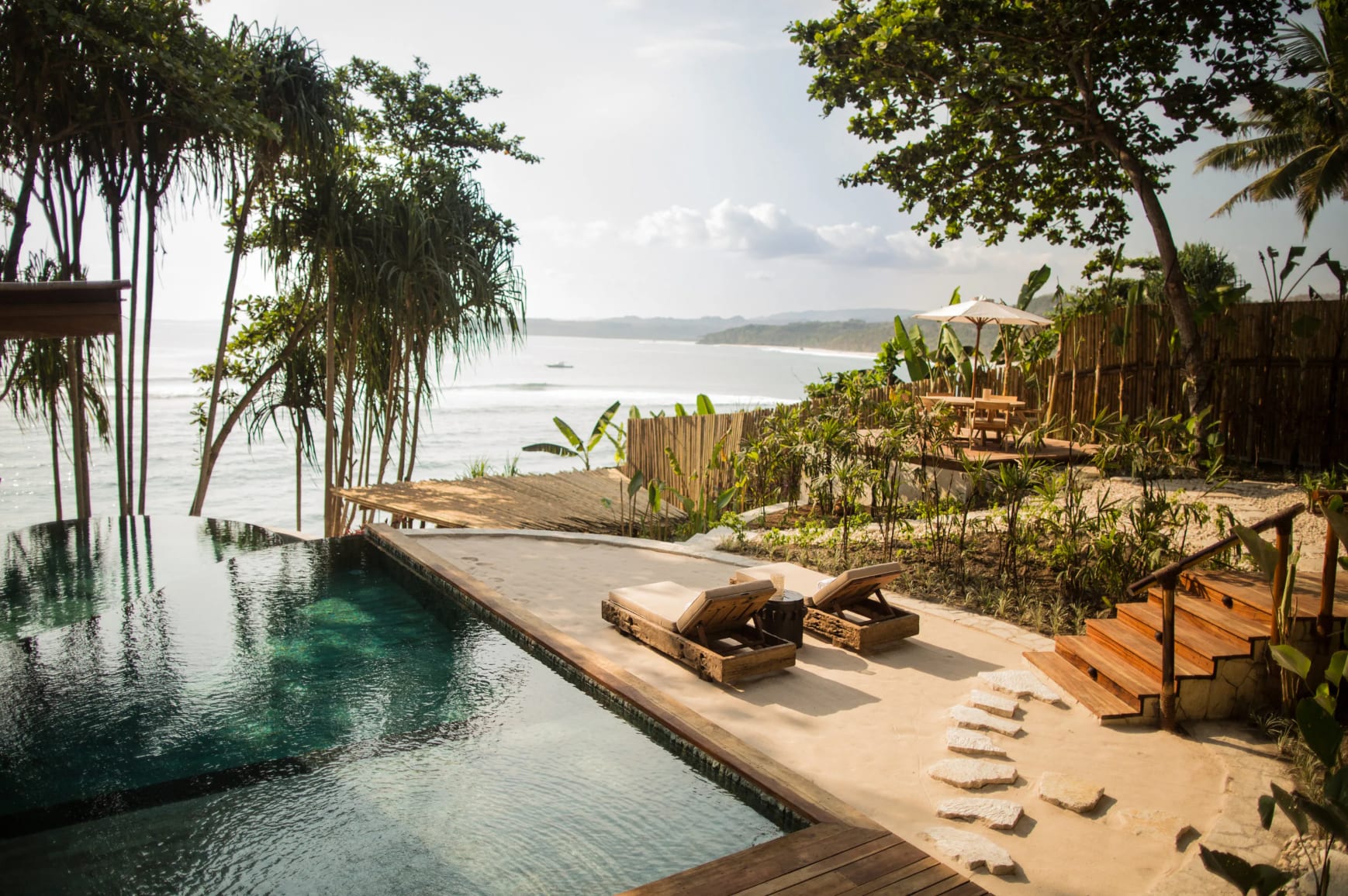 A hotel infinity pool with lush surroundings overlooking the ocean