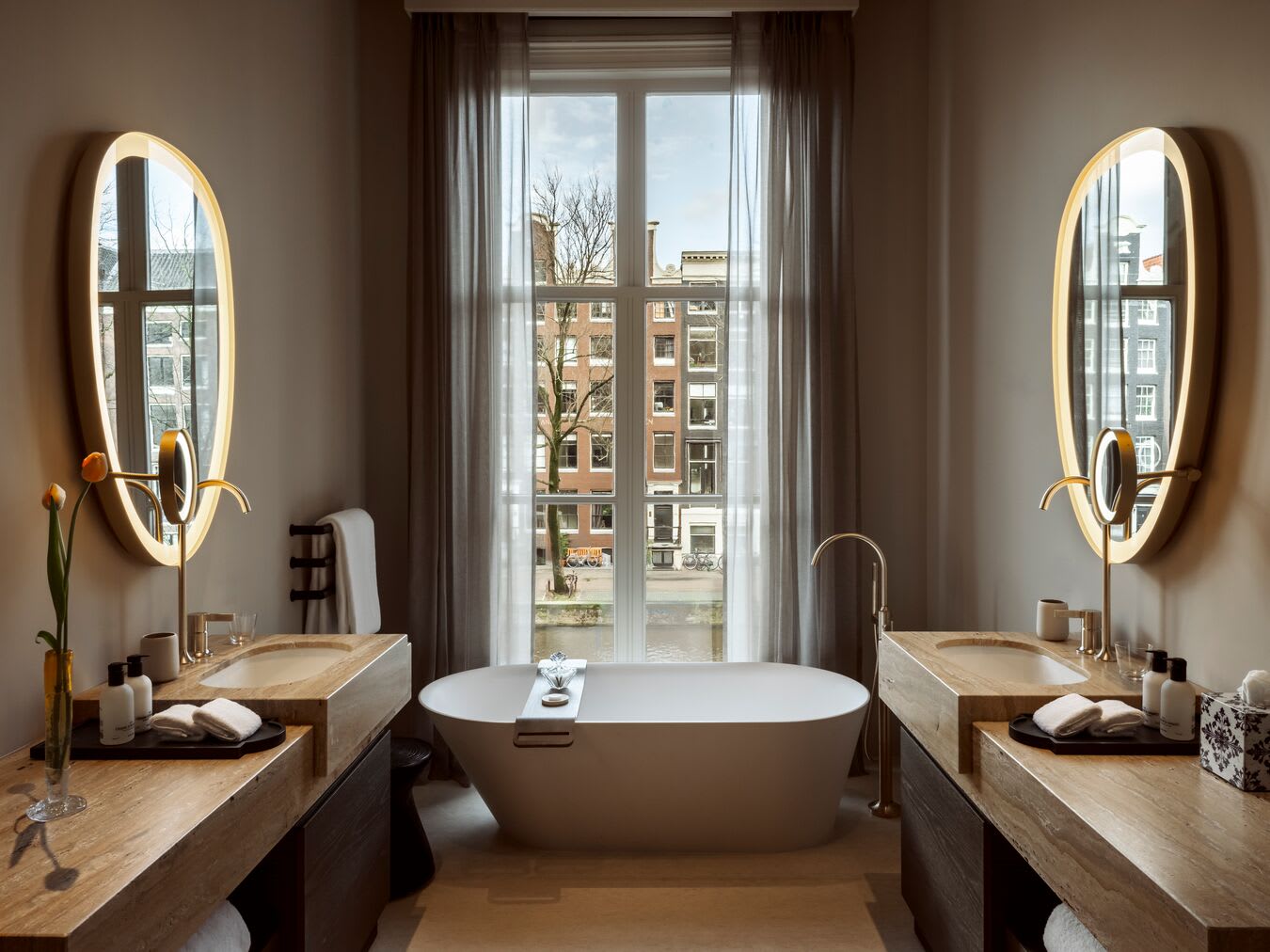 a luxe bathroom with a standing white tub overlooking an Amsterdam canal