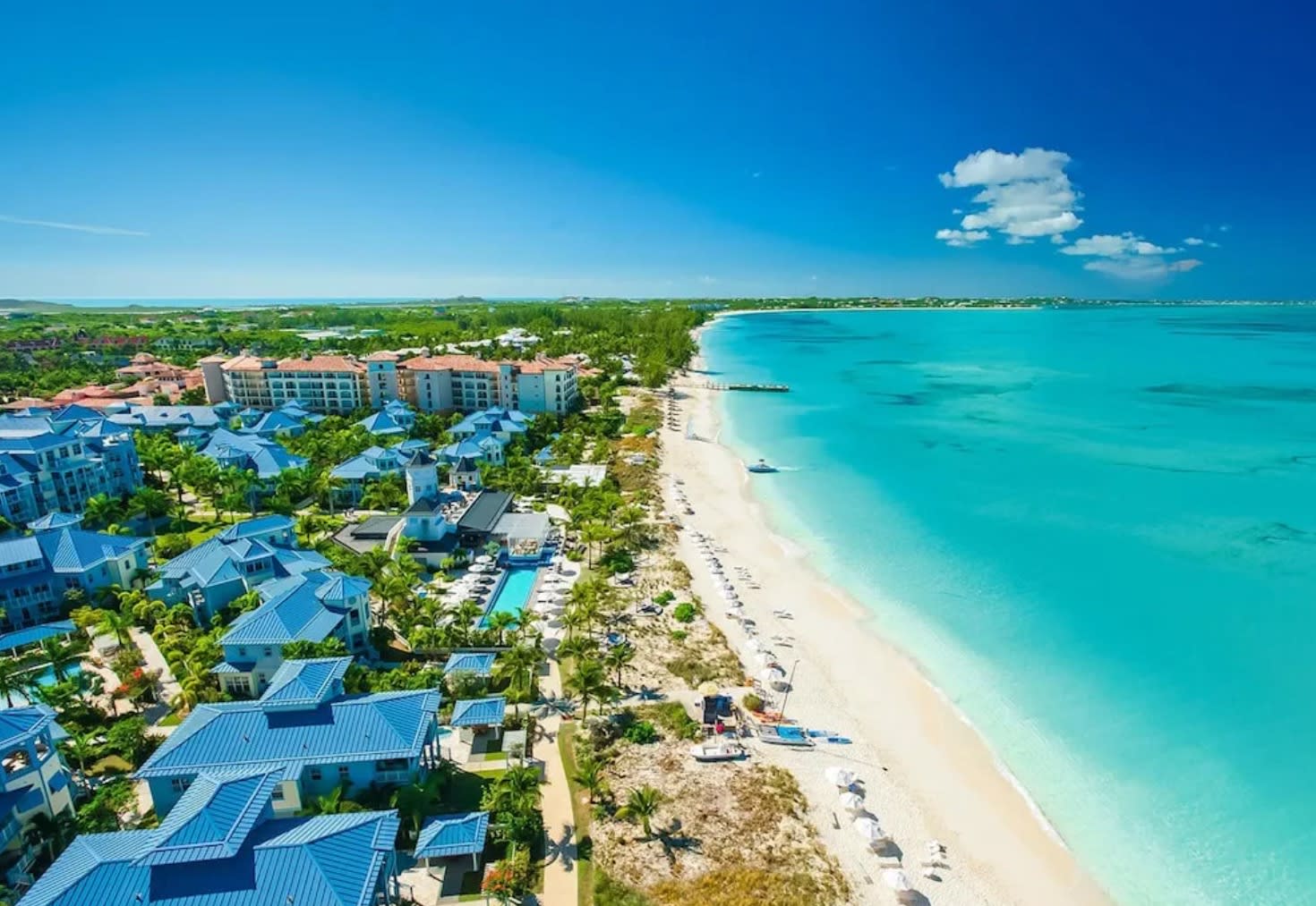 aerial view of a beach with houses and turquoise sea