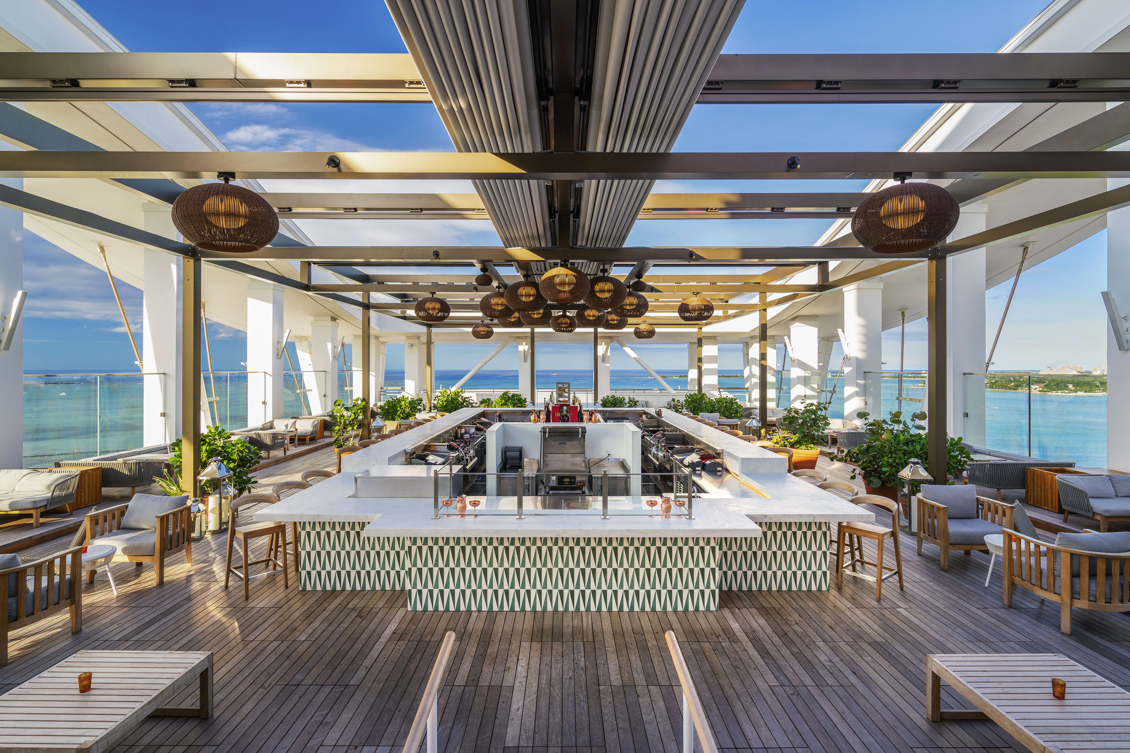 A modern open-air bar and terrace area with ocean views