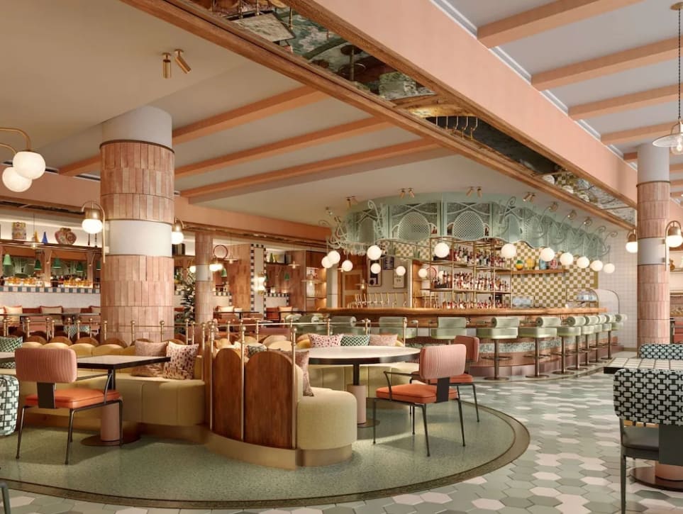 Elegant hotel restaurant area with pastel pink and green decor and hanging lights.