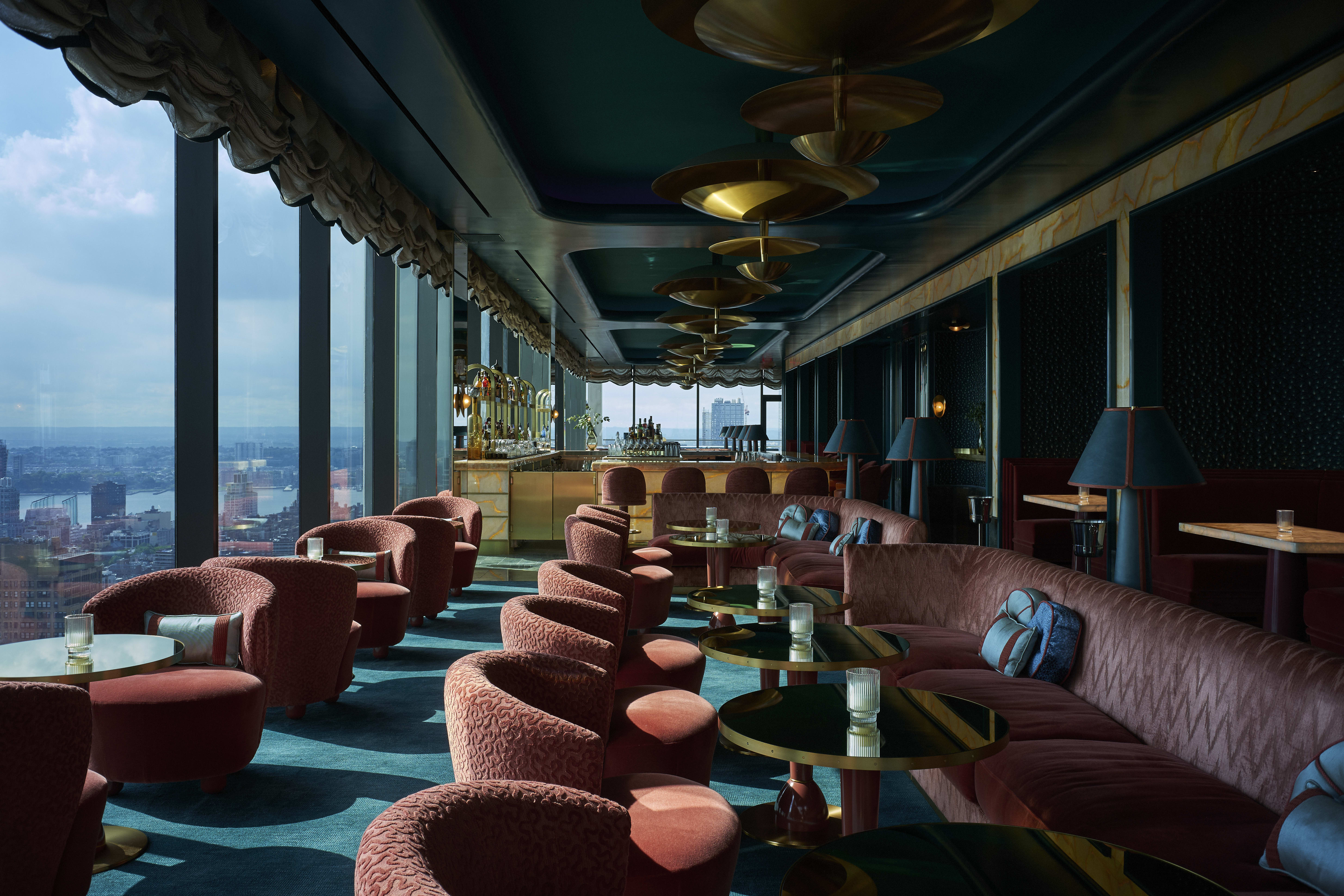 A bar with city views and plush green and brown seating