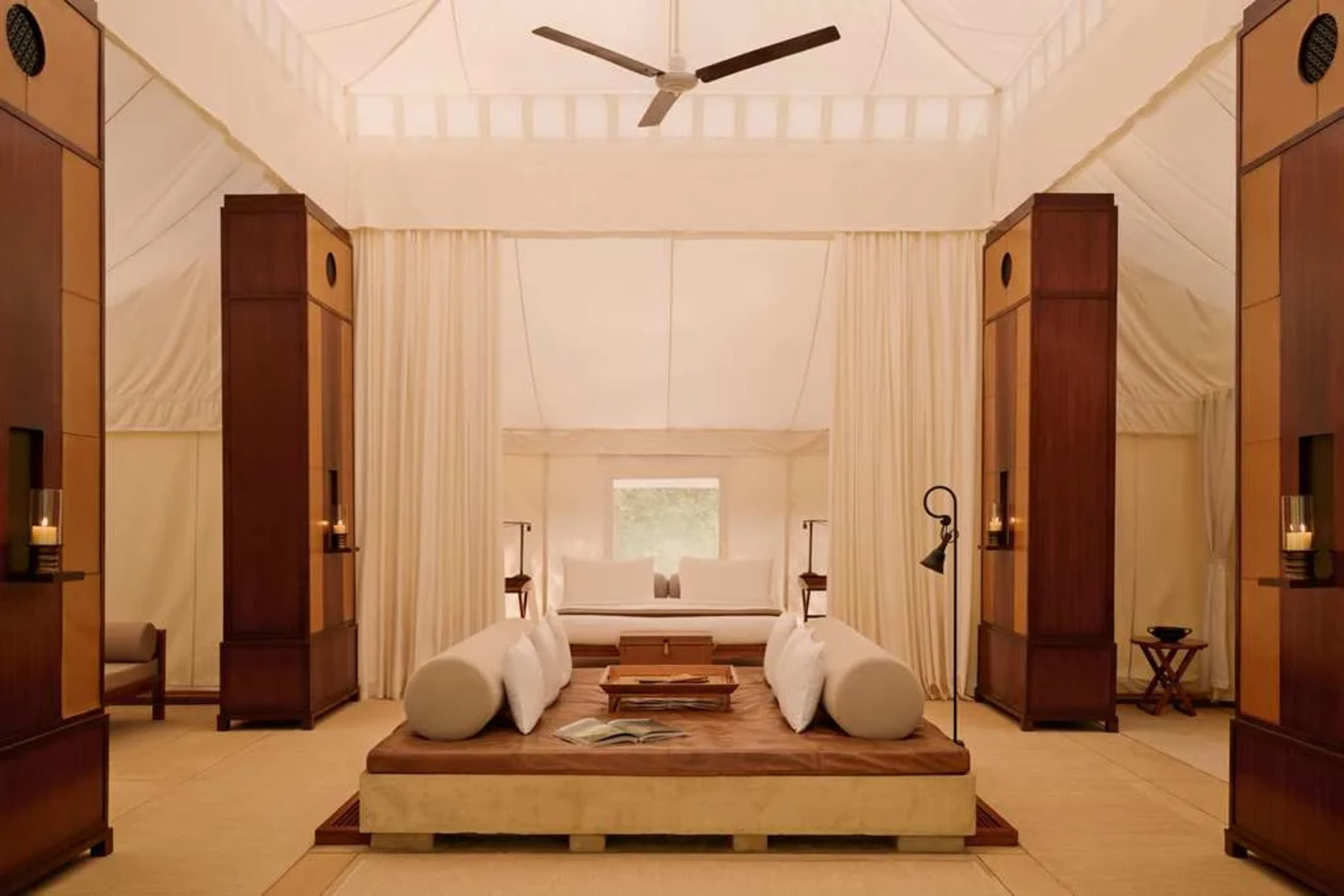 Elegant furnishings under a canvas-walled room with a day bed at the center