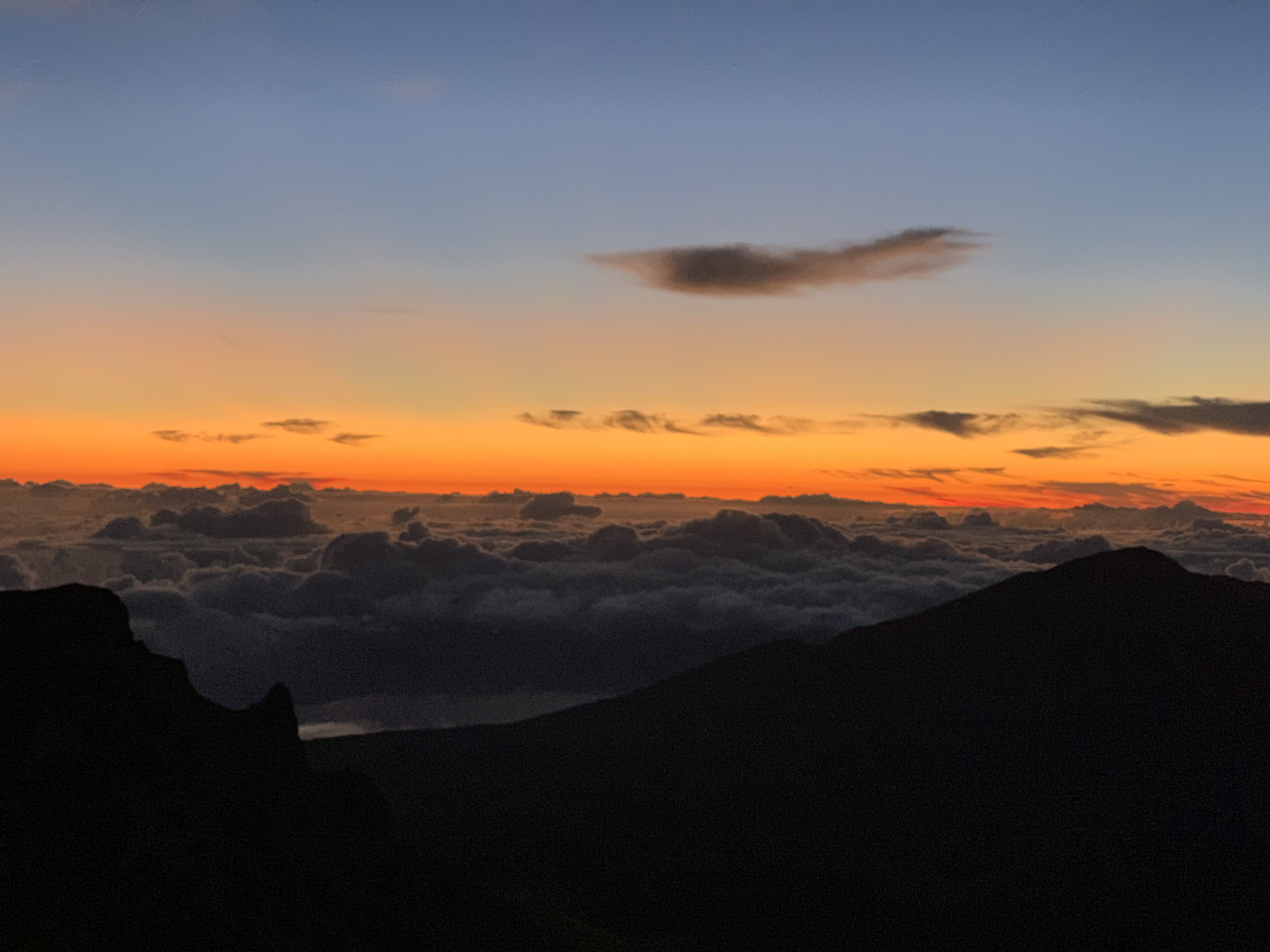 view of the sun rising above the clouds