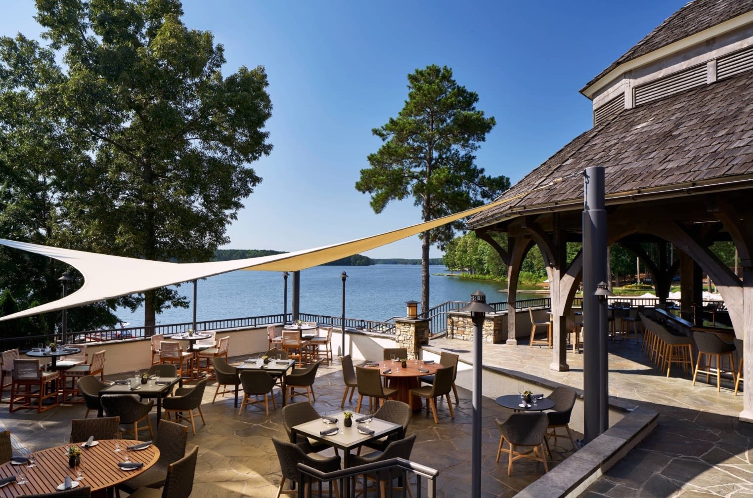 patio with outdoor dining and a lake view