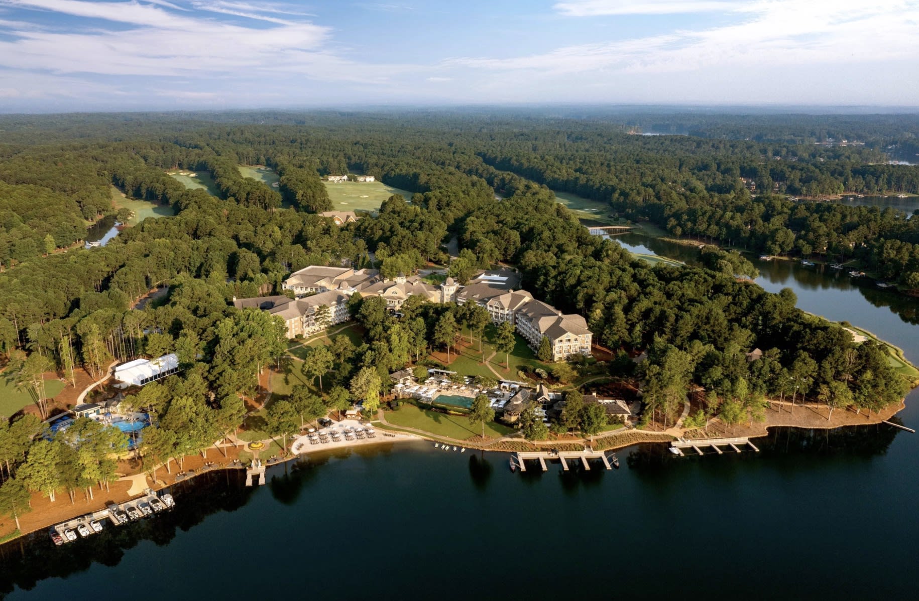 aerial shot of a lake with a resort and trees