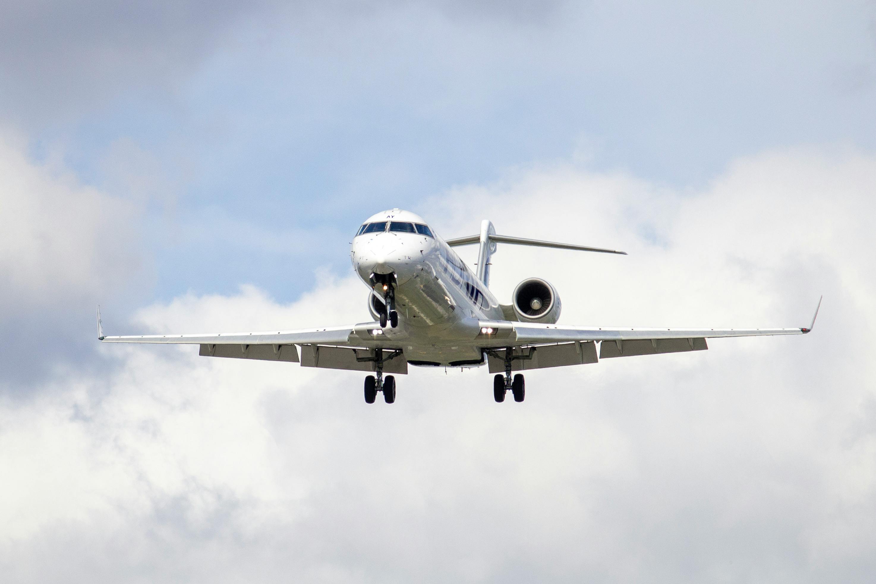 A plane flying with clouds in the background