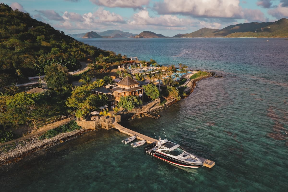 aerial view of buildings and a pier on a tropical island