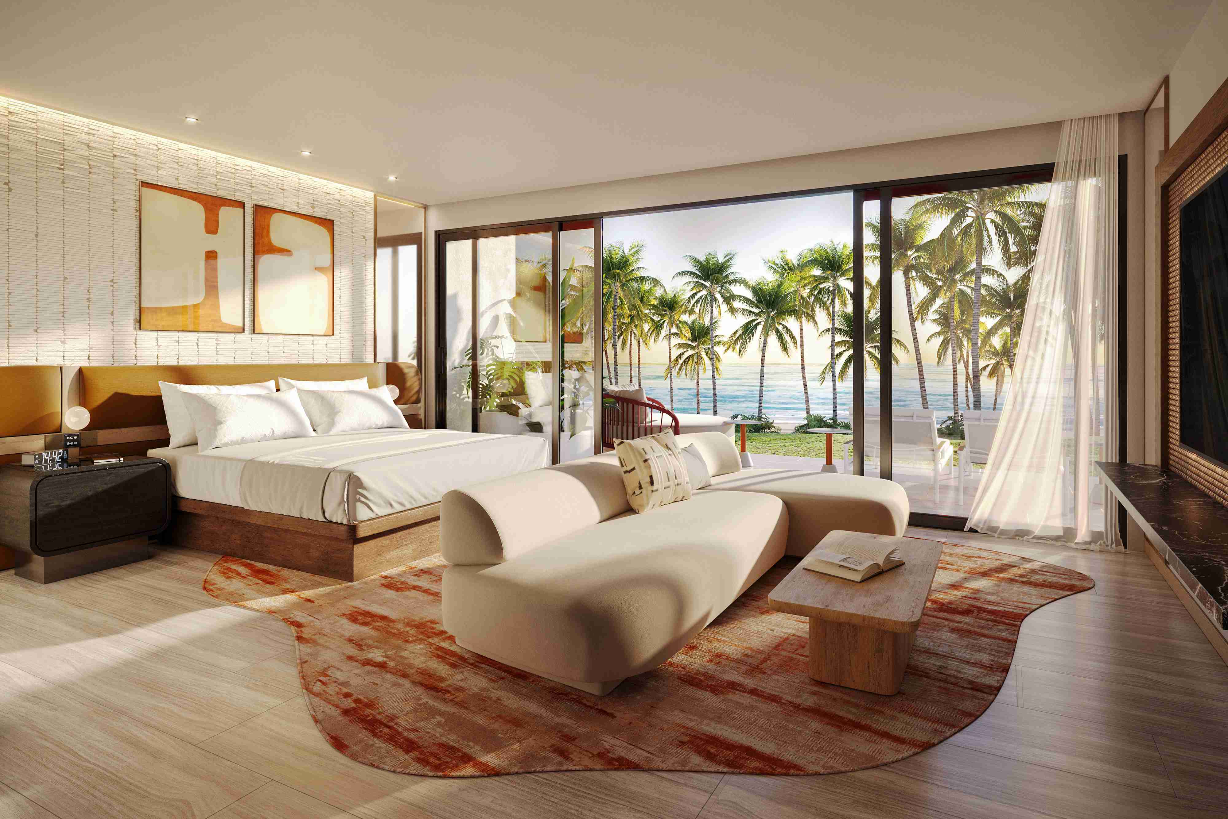 A spacious hotel suite with cream and neutral decor and large sliding doors leading out to a terrace with views of palm trees and the ocean
