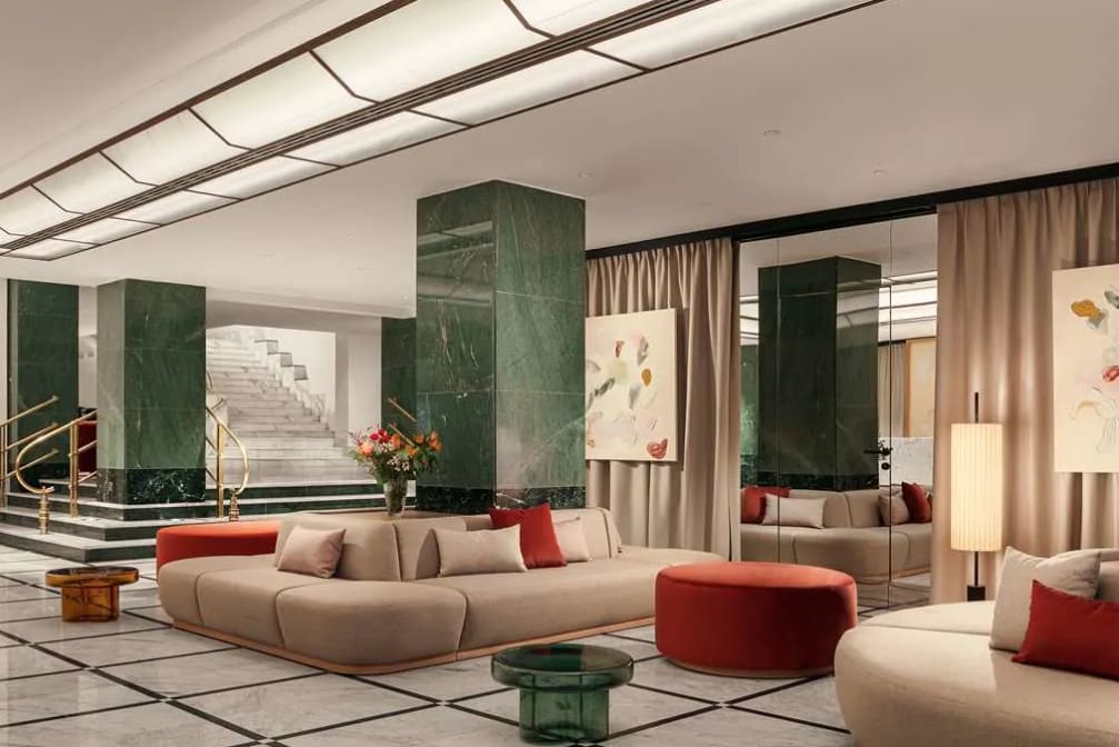 Hotel lobby area with green pillars, cream lounge seating and orange decoration
