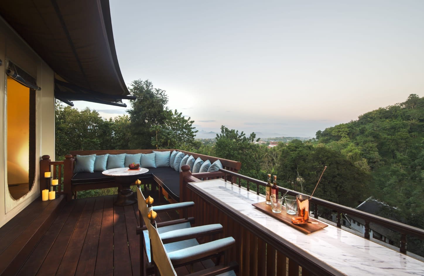 outdoor porch with seating overlooking a jungle with sky in the distance