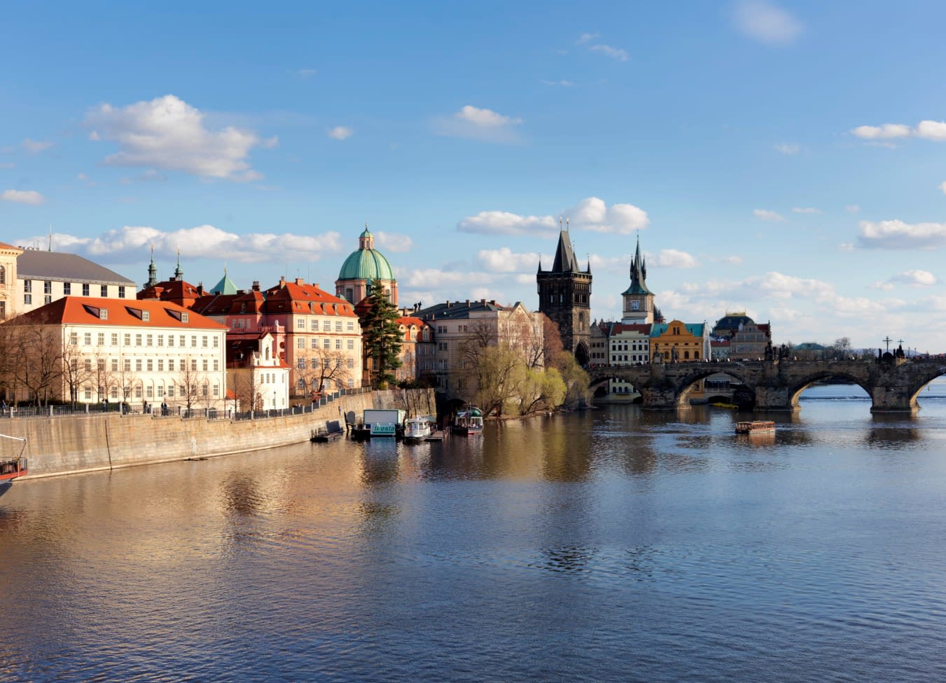 a river with historic buildings on the shore and a bridge