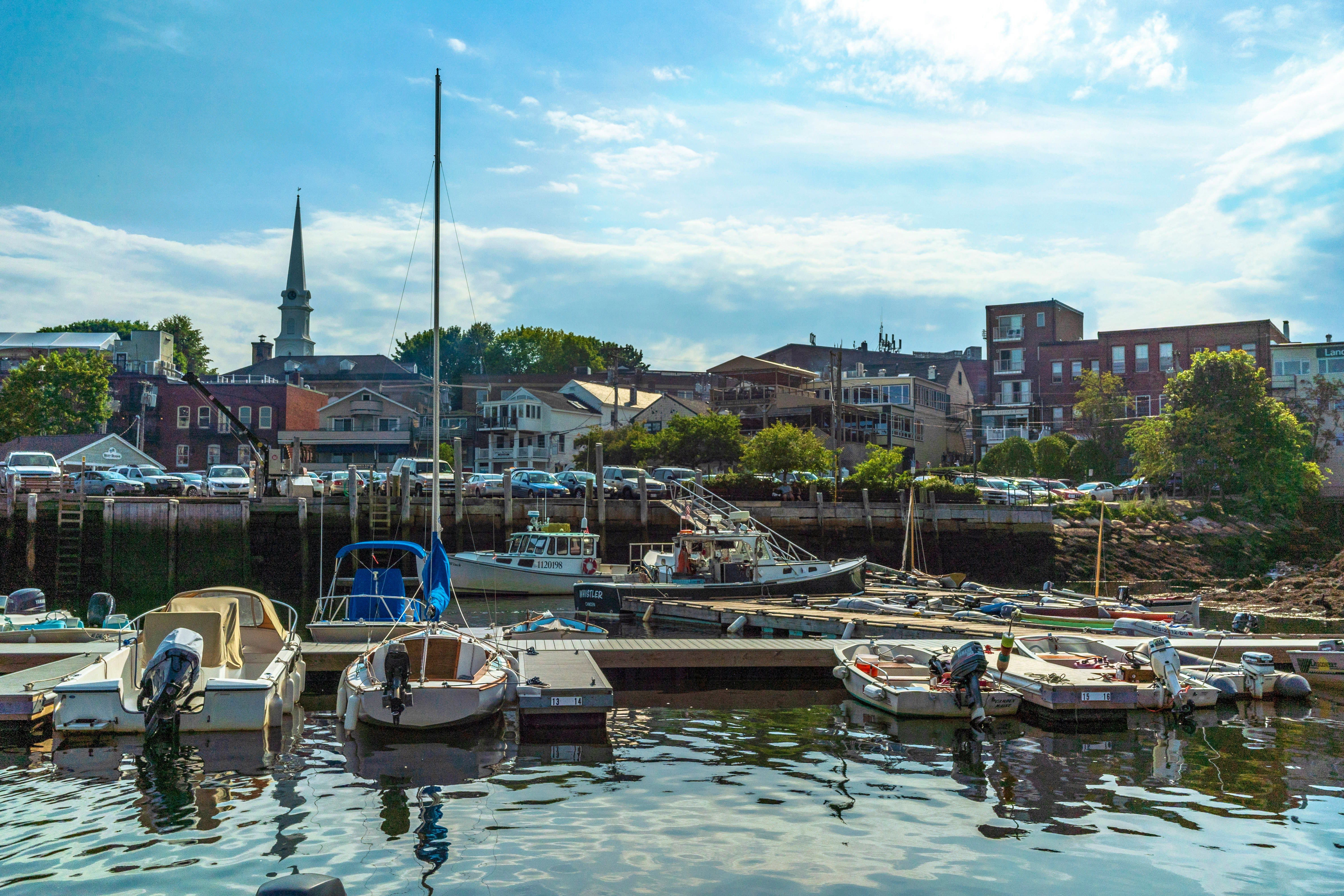 Scenic view of Camden Harbor in Maine with docked boats and a charming town backdrop featuring a church steeple.