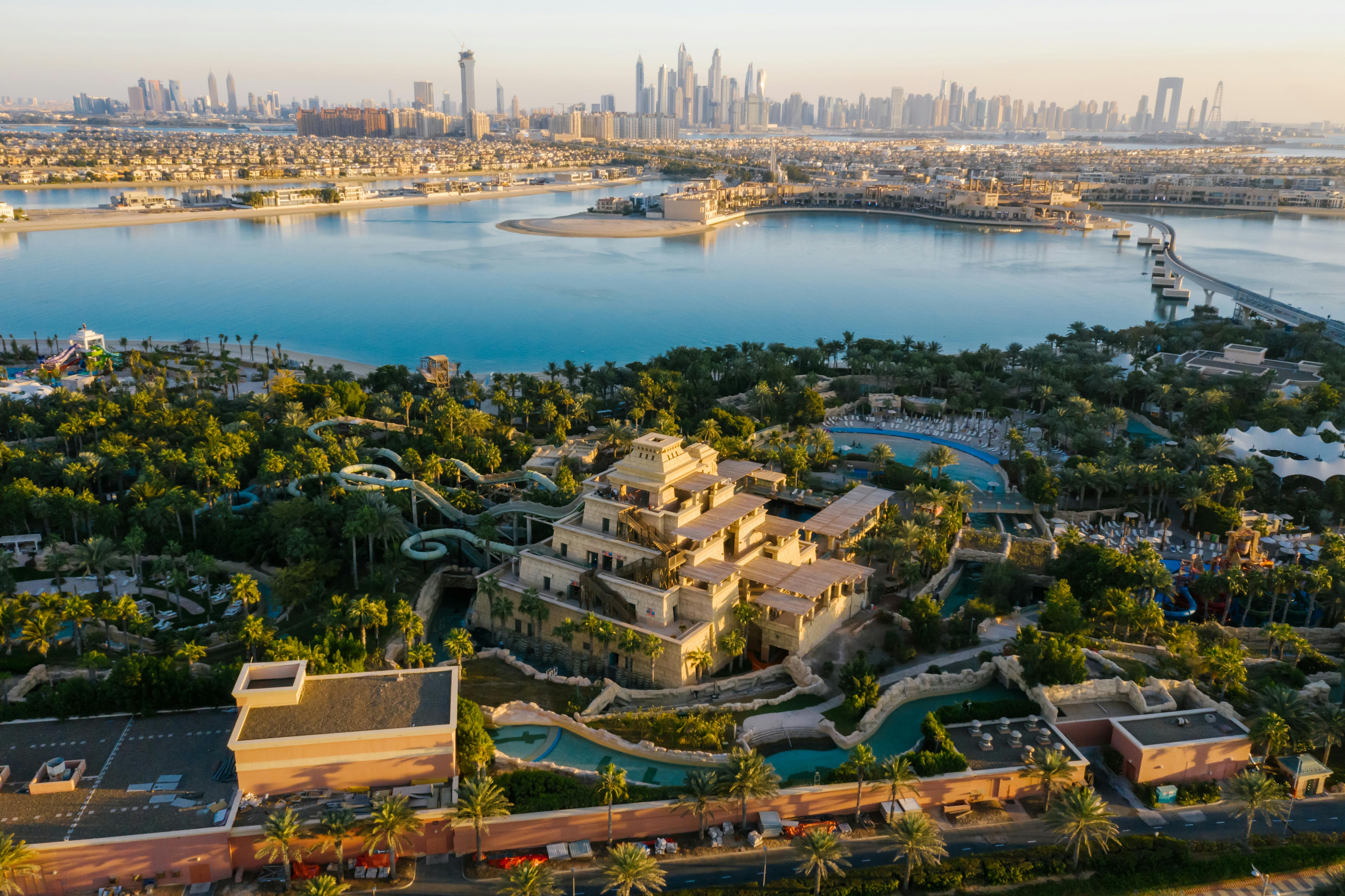 aerial view of a water park with water behind it and a cityscape beyond