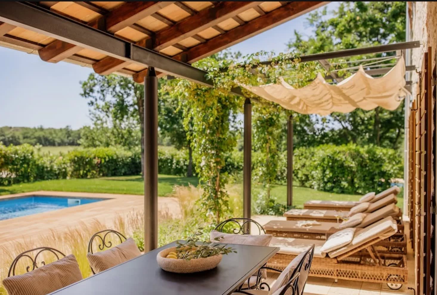 outdoor terrace with loungers by a pool