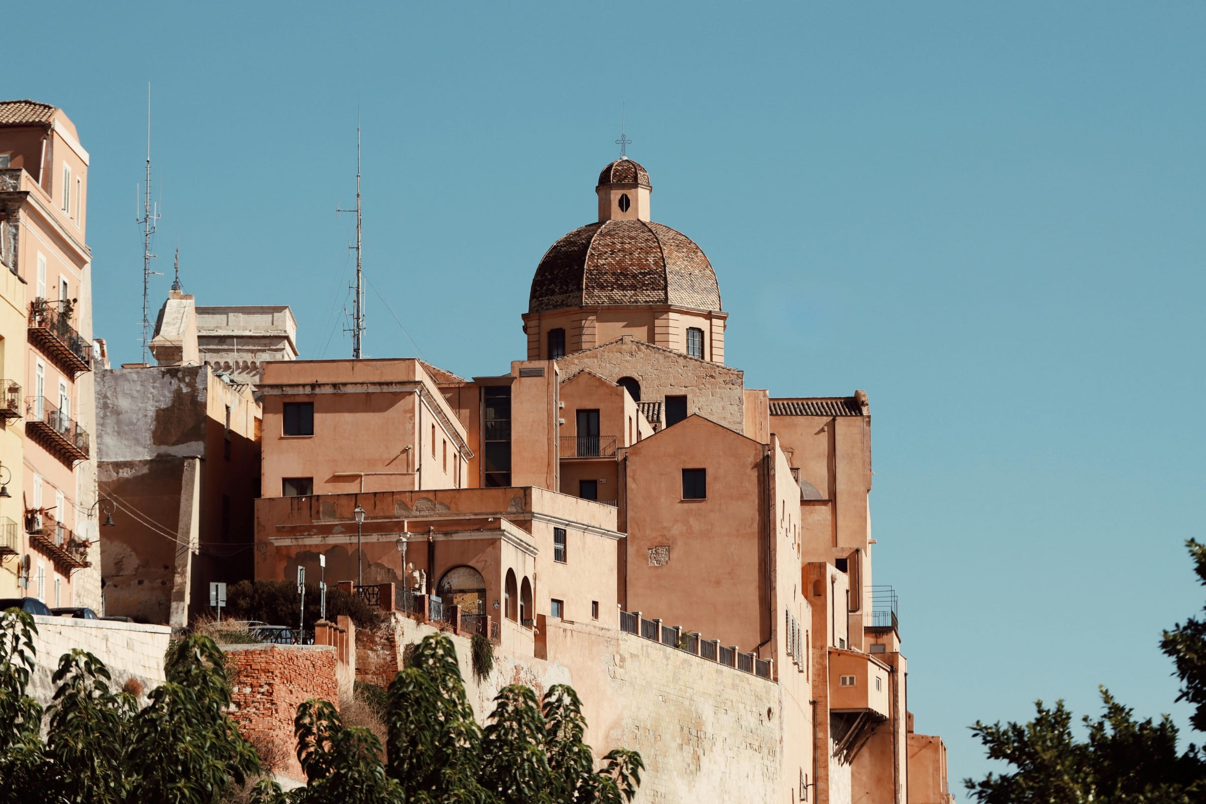 A cathedral dome above ancient town homes during day