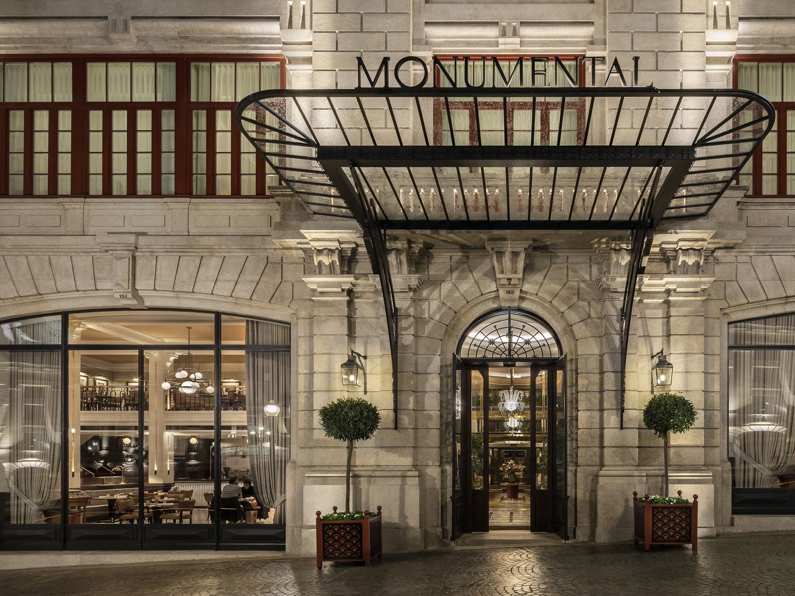 Ornate entrance of period building with glass awning at night