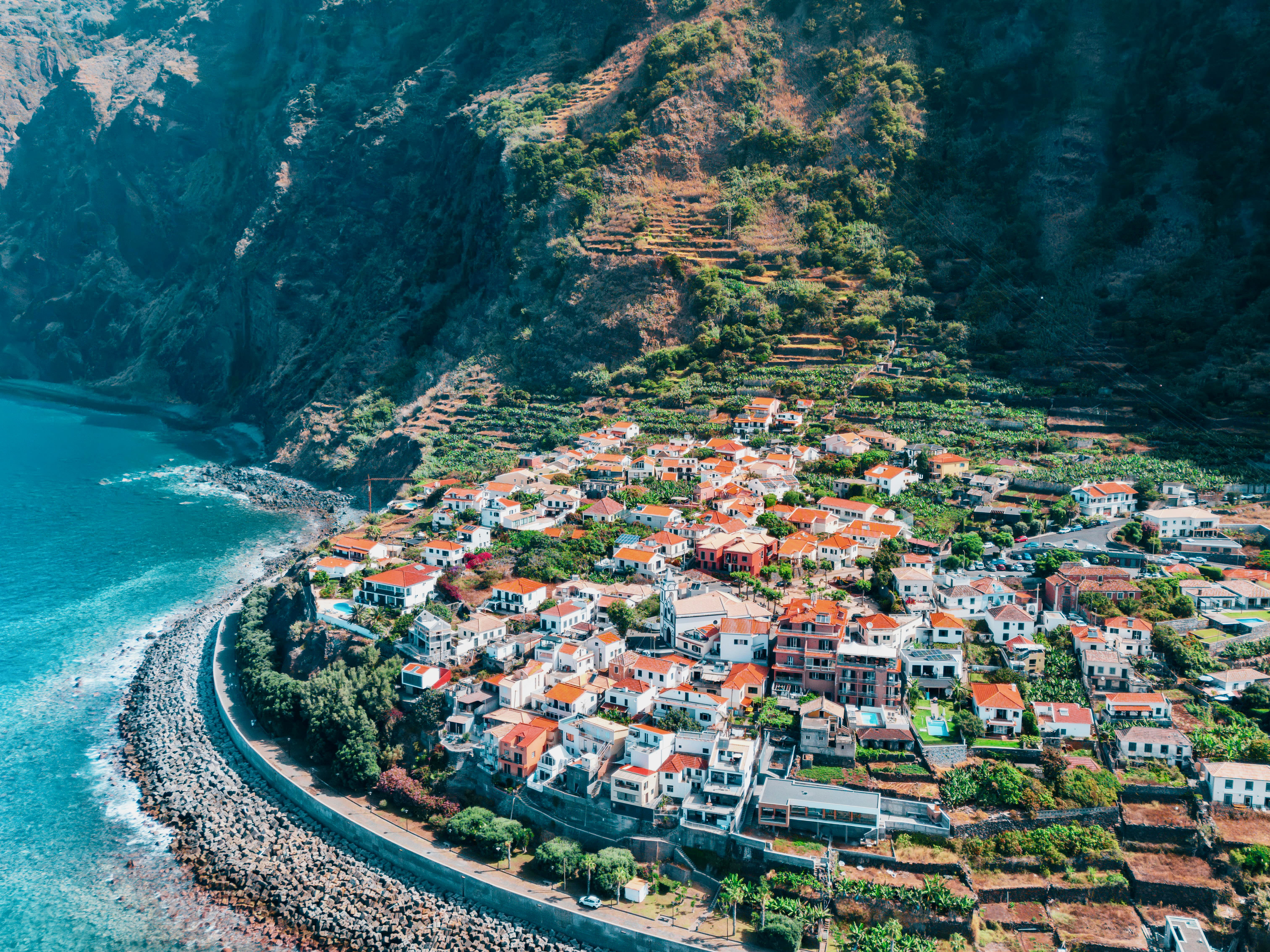 Aerial view of town at the base of a hill along the ocean during day