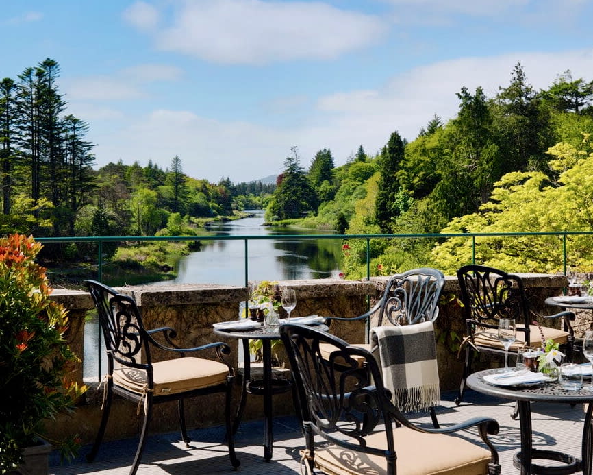 outdoor dining area next to a river and green forest at daytime