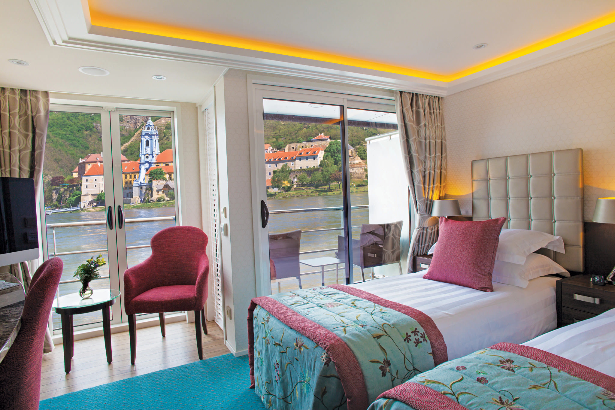 colorful cruise cabin with river view beyond sliding glass doors