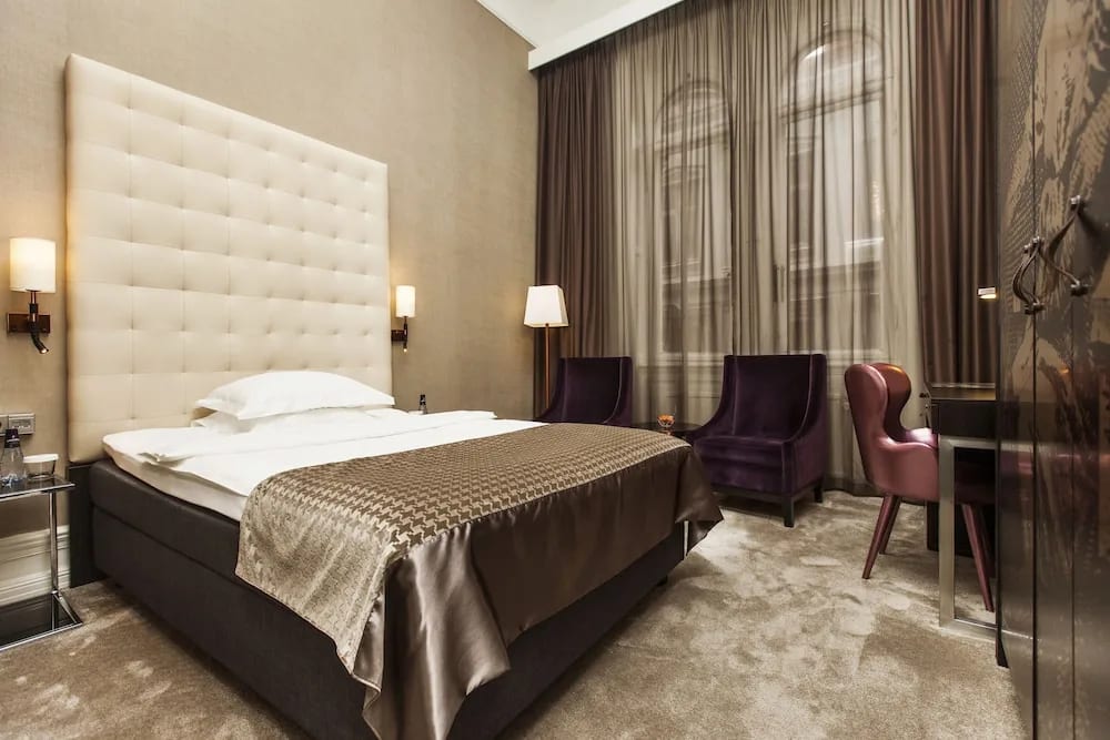 earth tone hotel room with beige carpet, dark brown furniture and cream color walls