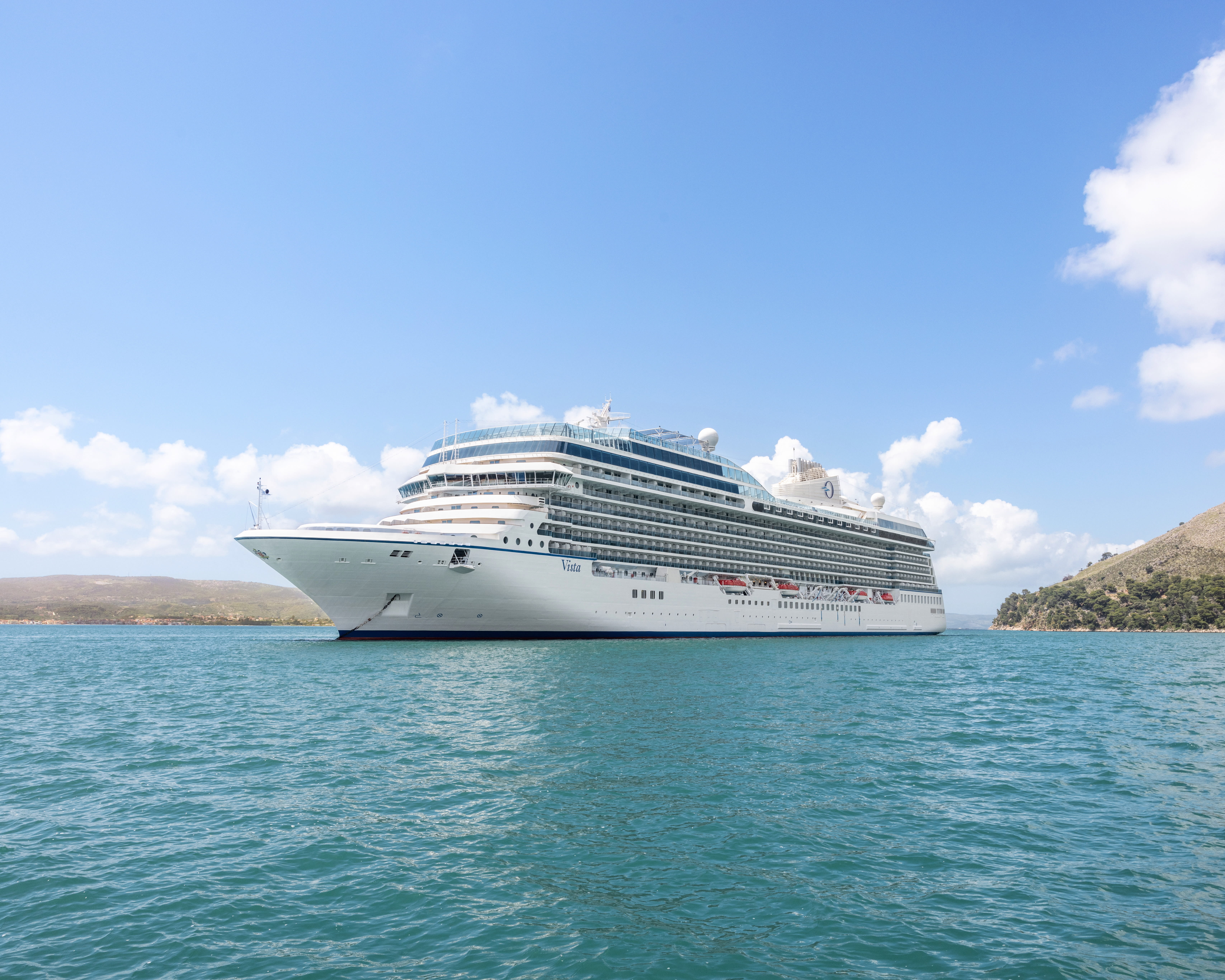 white cruise ship on turquoise ocean waters during day