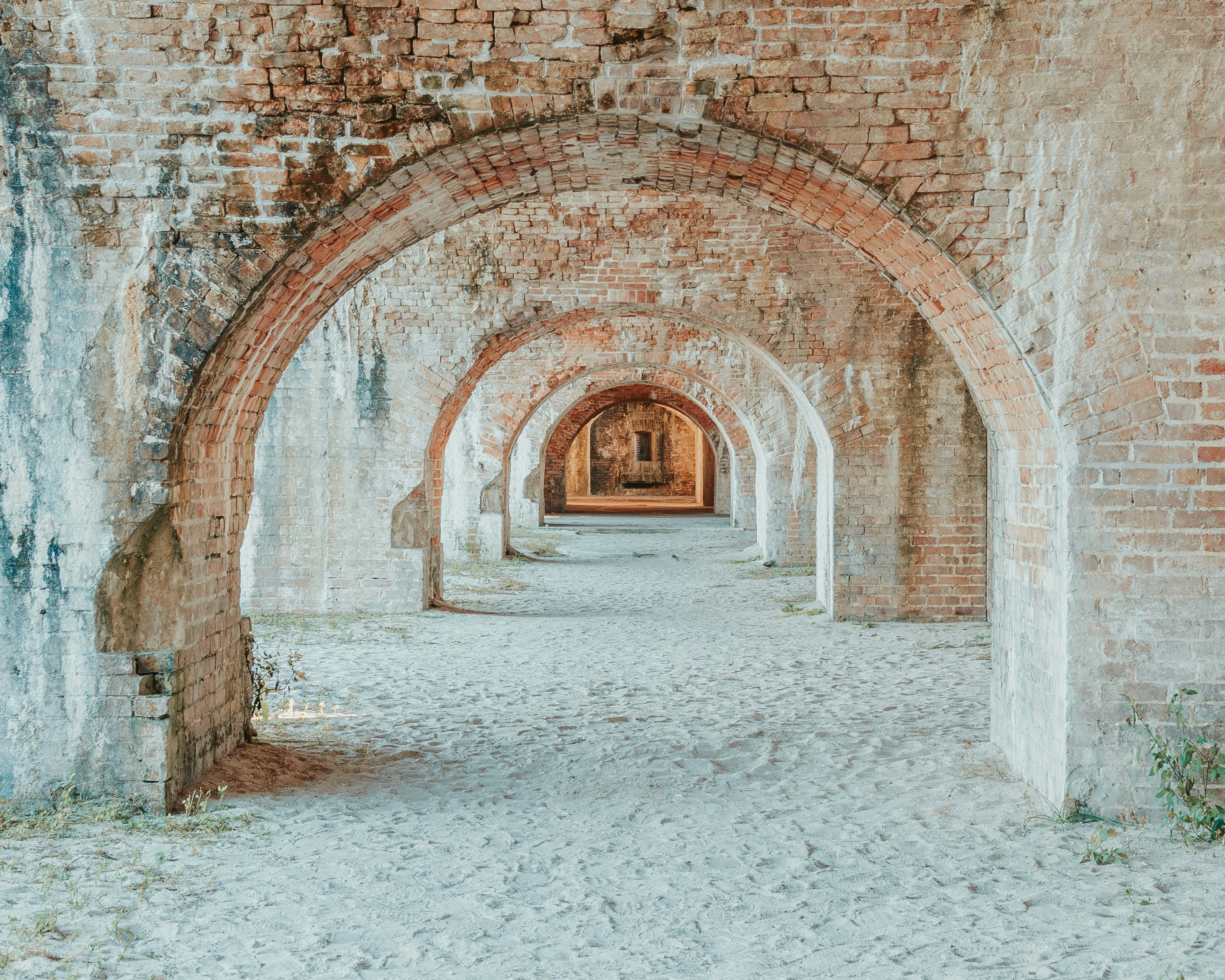 dirt hallway with rustic brick arches in an abandoned fort