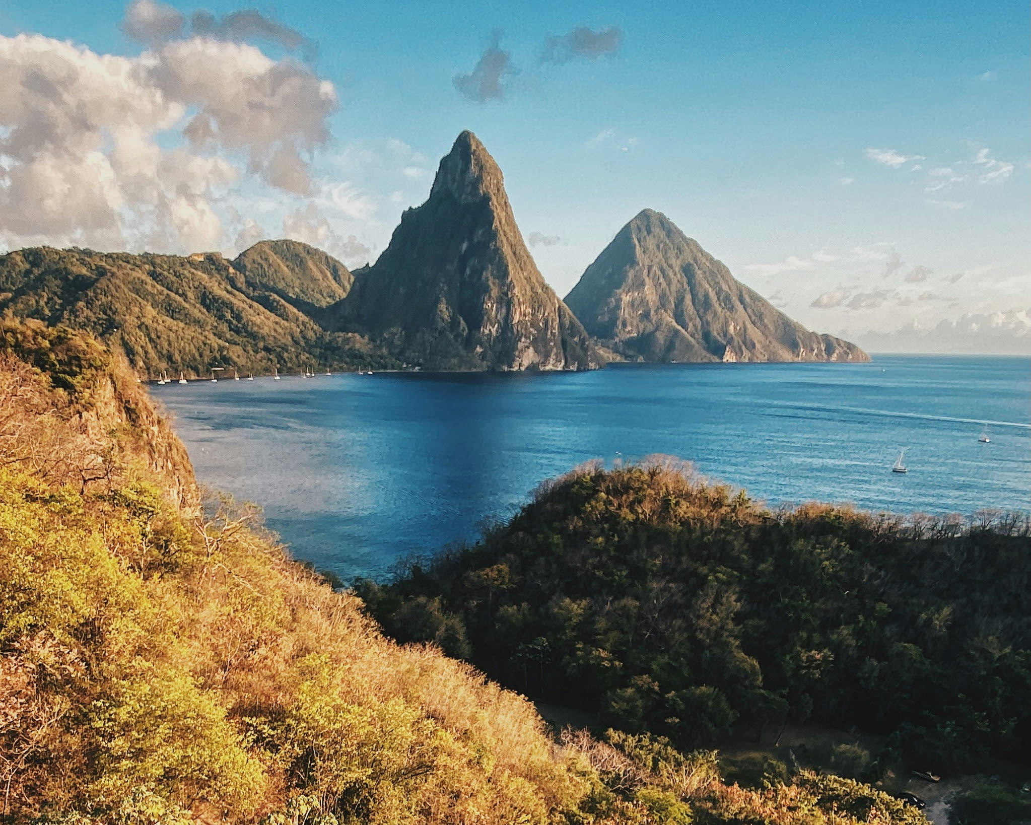 mountainous island peaks next to ocean during day